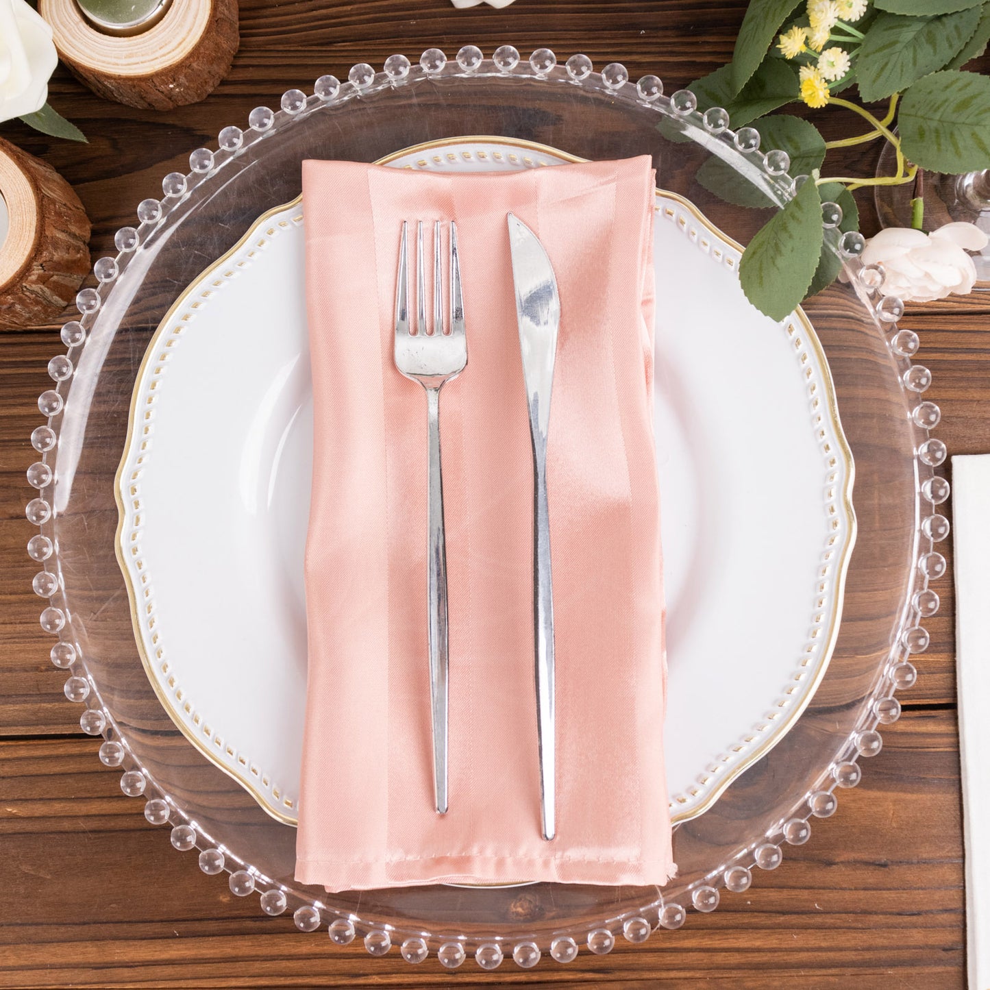 Dusty rose striped satin linen napkin on an elegant table setting.