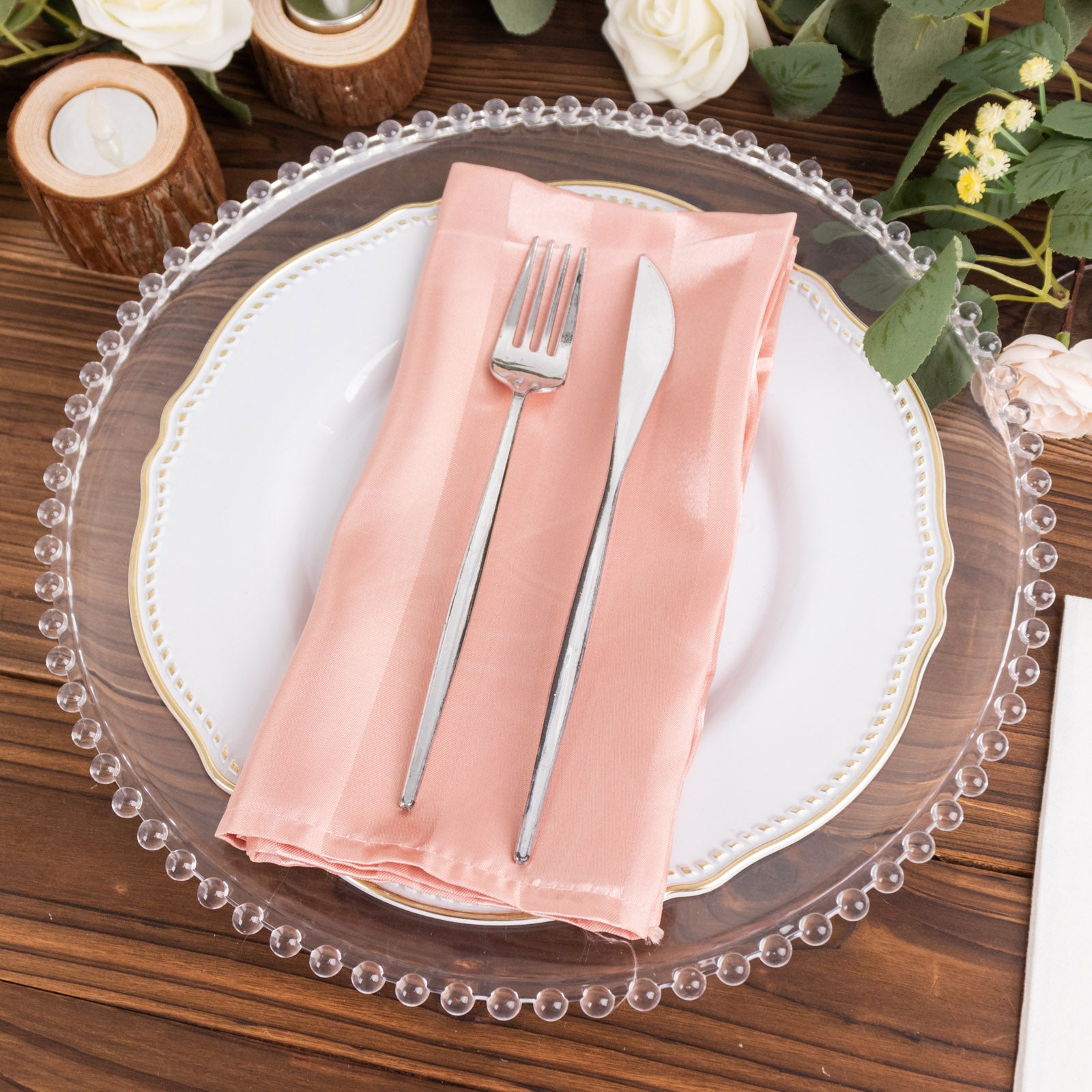Dusty rose satin linen napkin on a decorative plate setting.