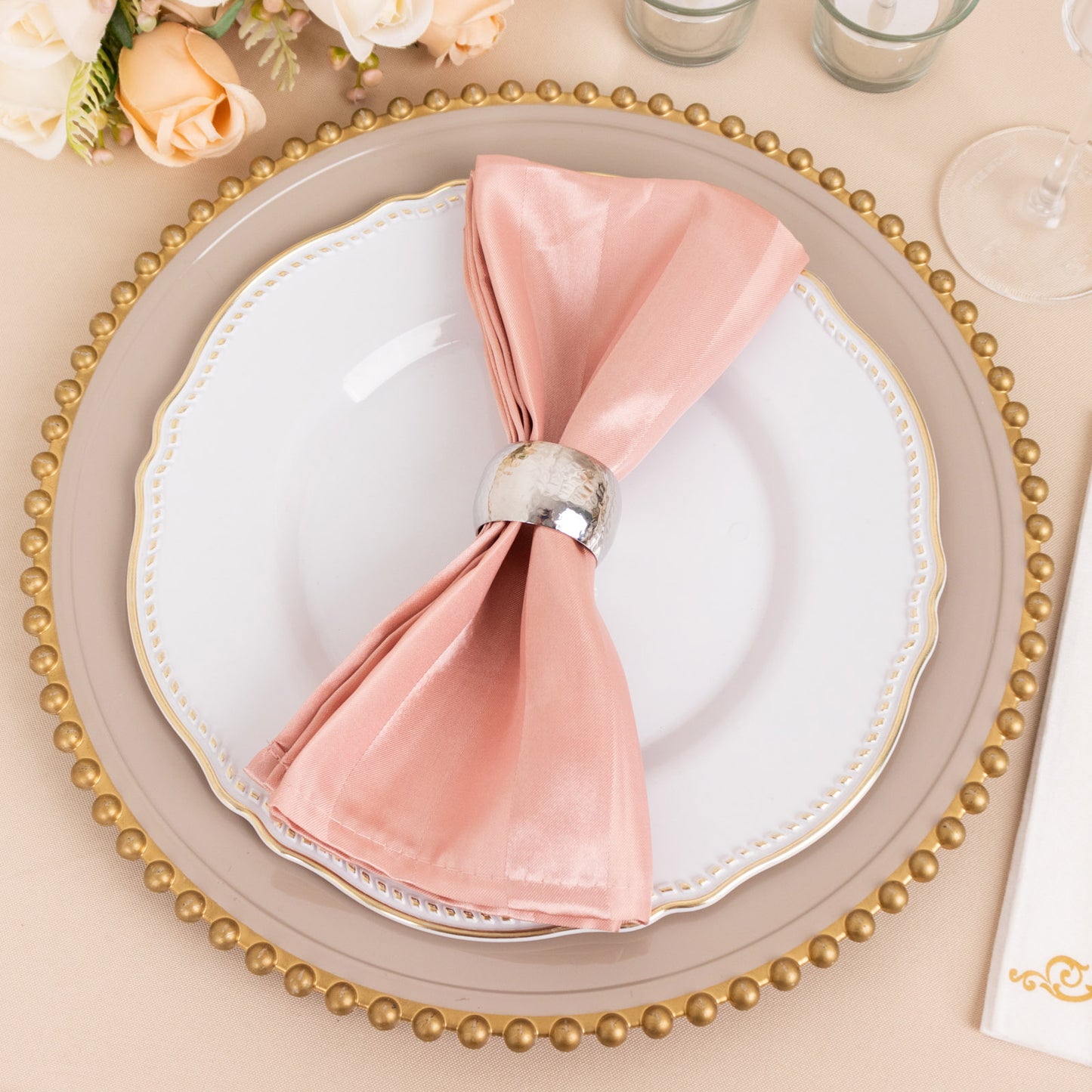 Dusty rose satin linen napkin elegantly arranged on a plate.