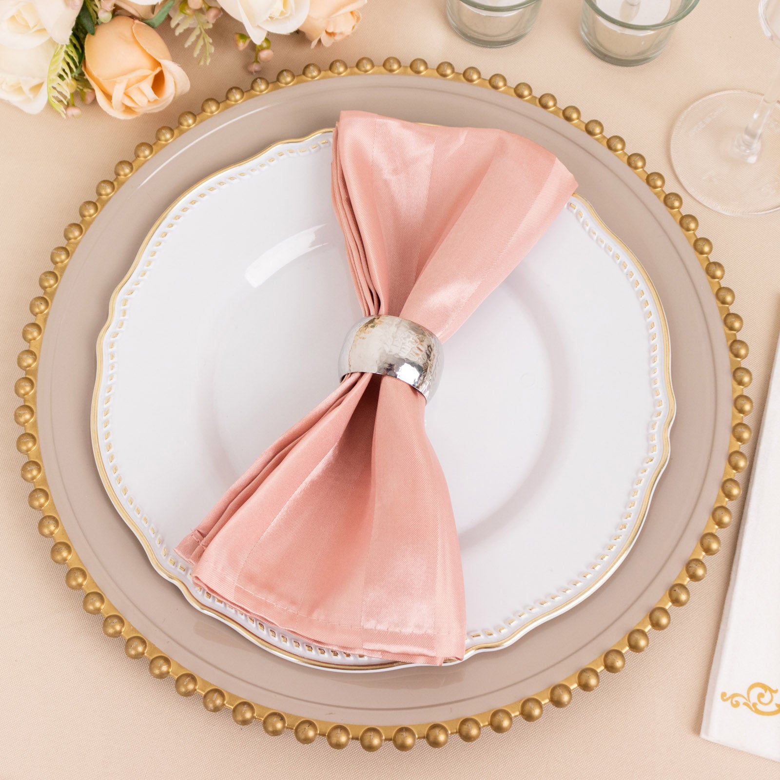 Dusty rose satin linen napkin elegantly arranged on a plate.
