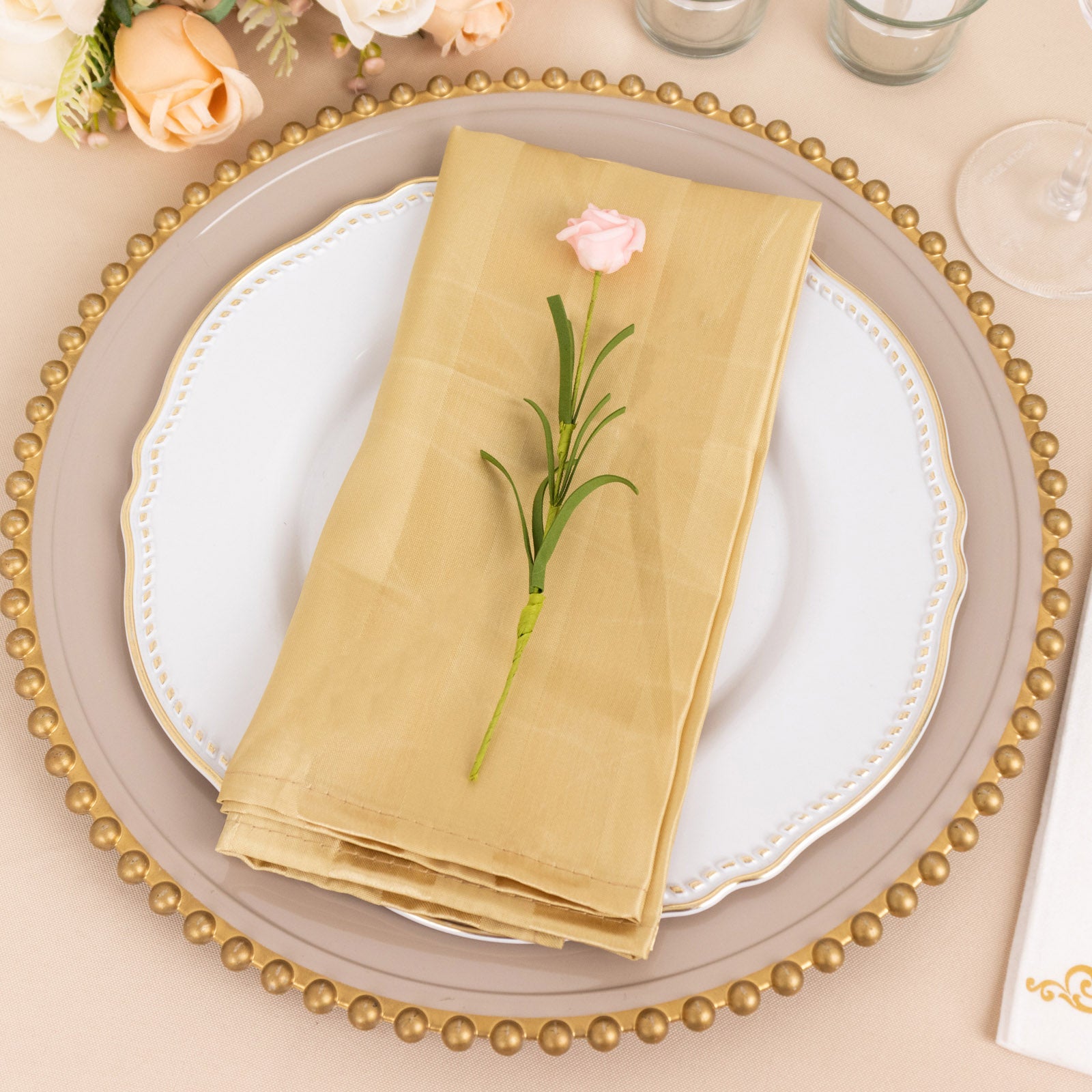 Champagne satin linen napkins on an elegant table setting.