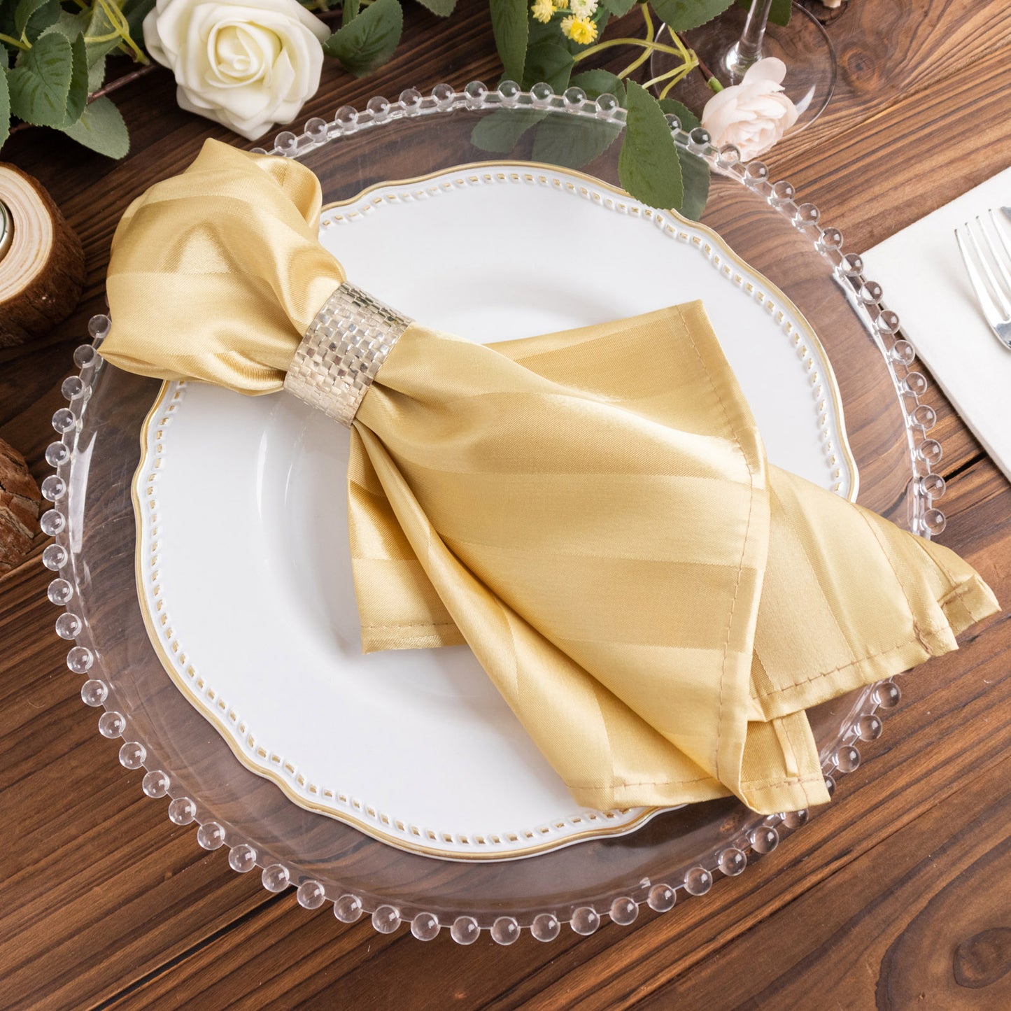 Champagne satin linen napkin elegantly arranged on a white plate.
