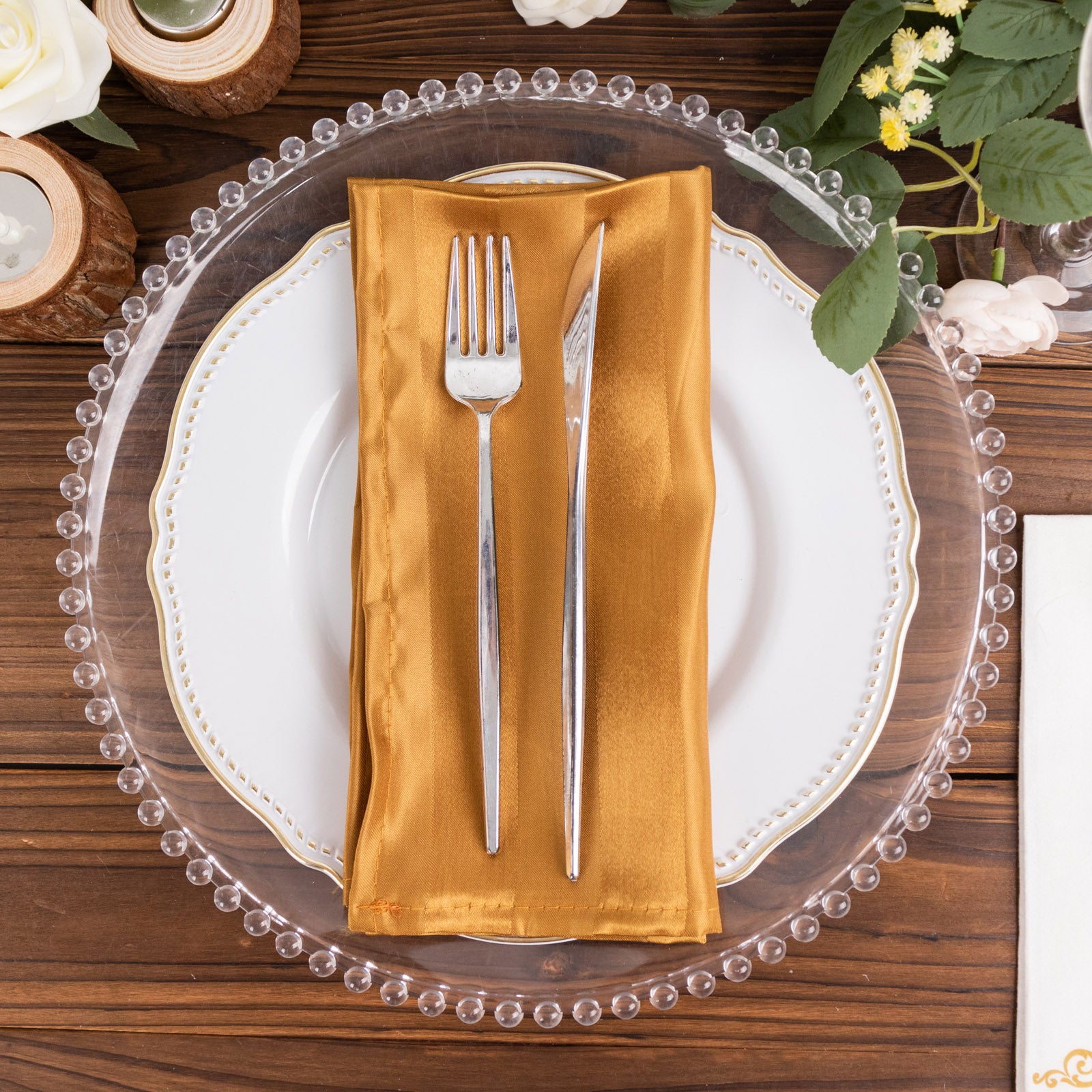 Gold satin linen napkin on a decorative plate setting.