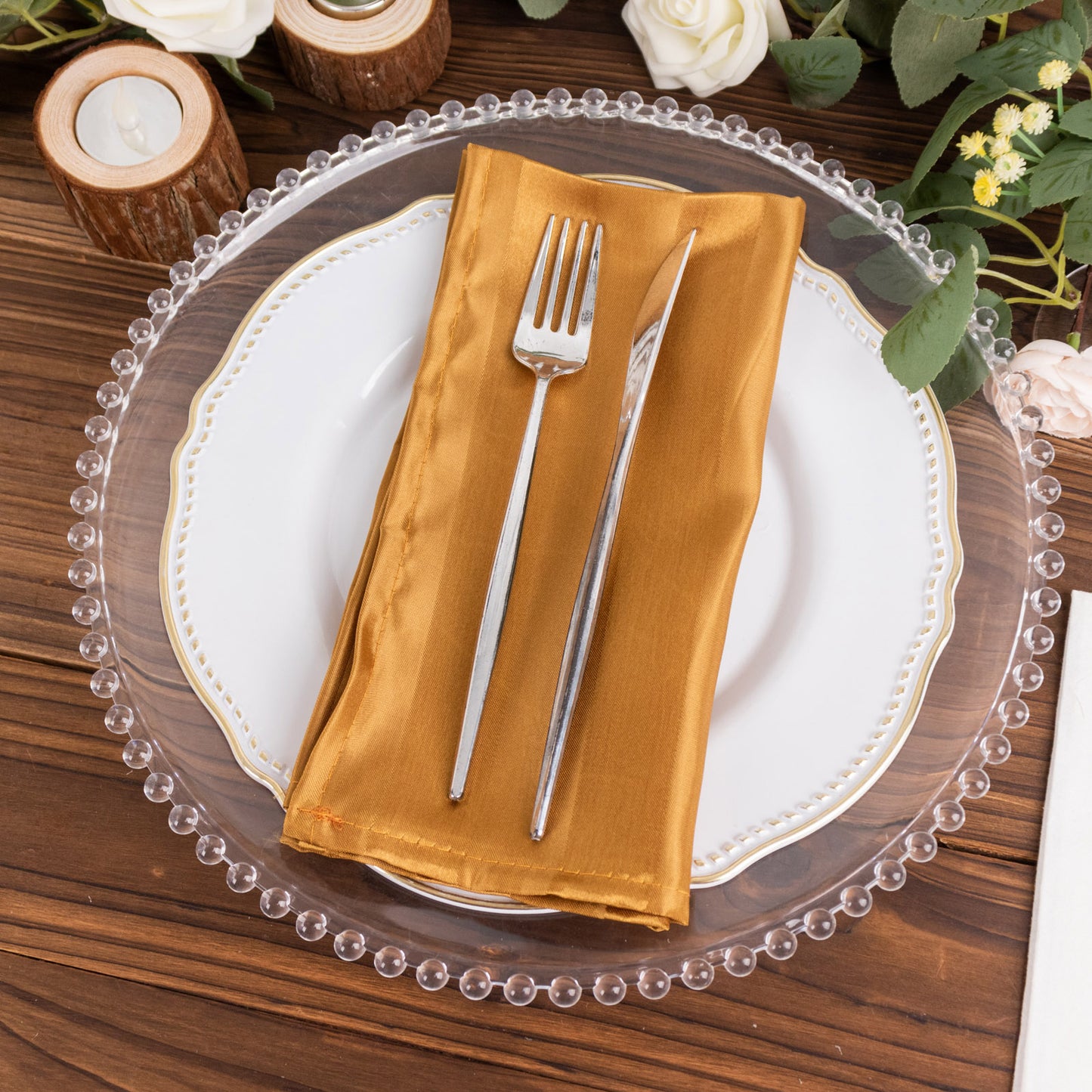 Gold satin linen napkin on a decorative plate.