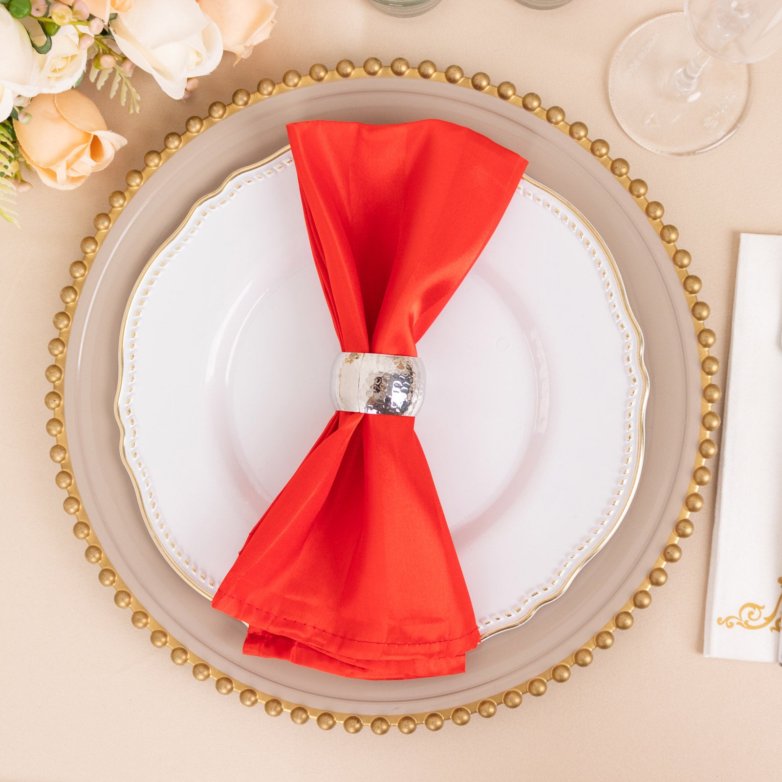 Red satin linen napkin elegantly displayed on a dining plate.