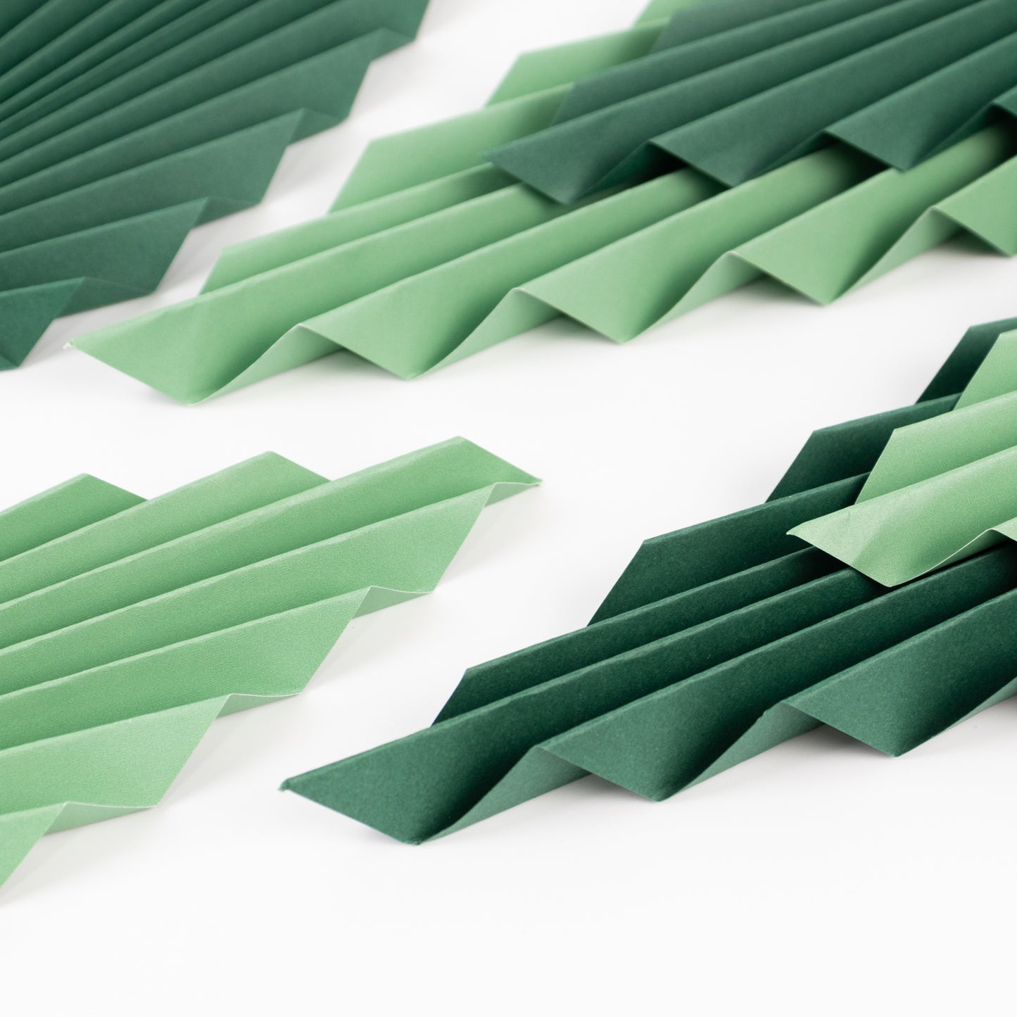 Set of 6 mixed green leaves hanging paper fans for tropical party decor.