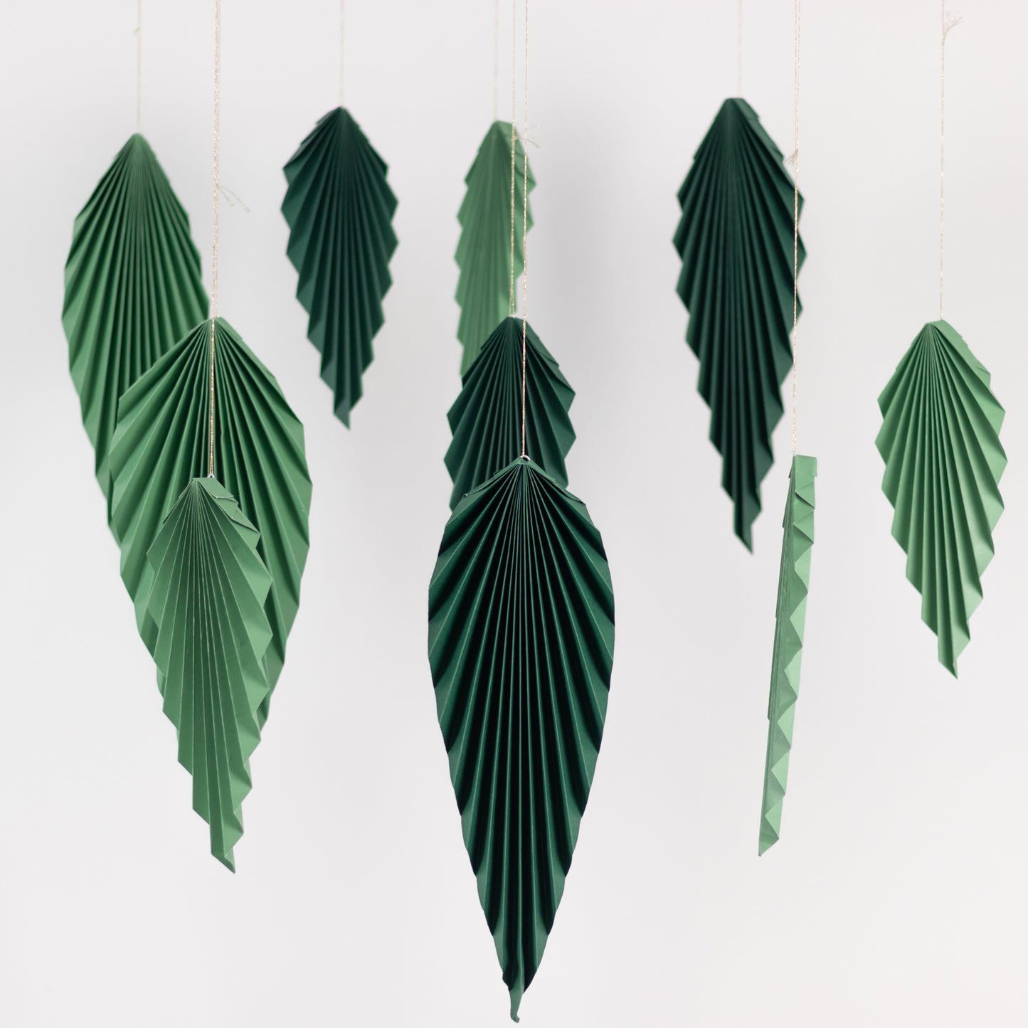 Set of 6 mixed green paper fans for tropical jungle theme decor.