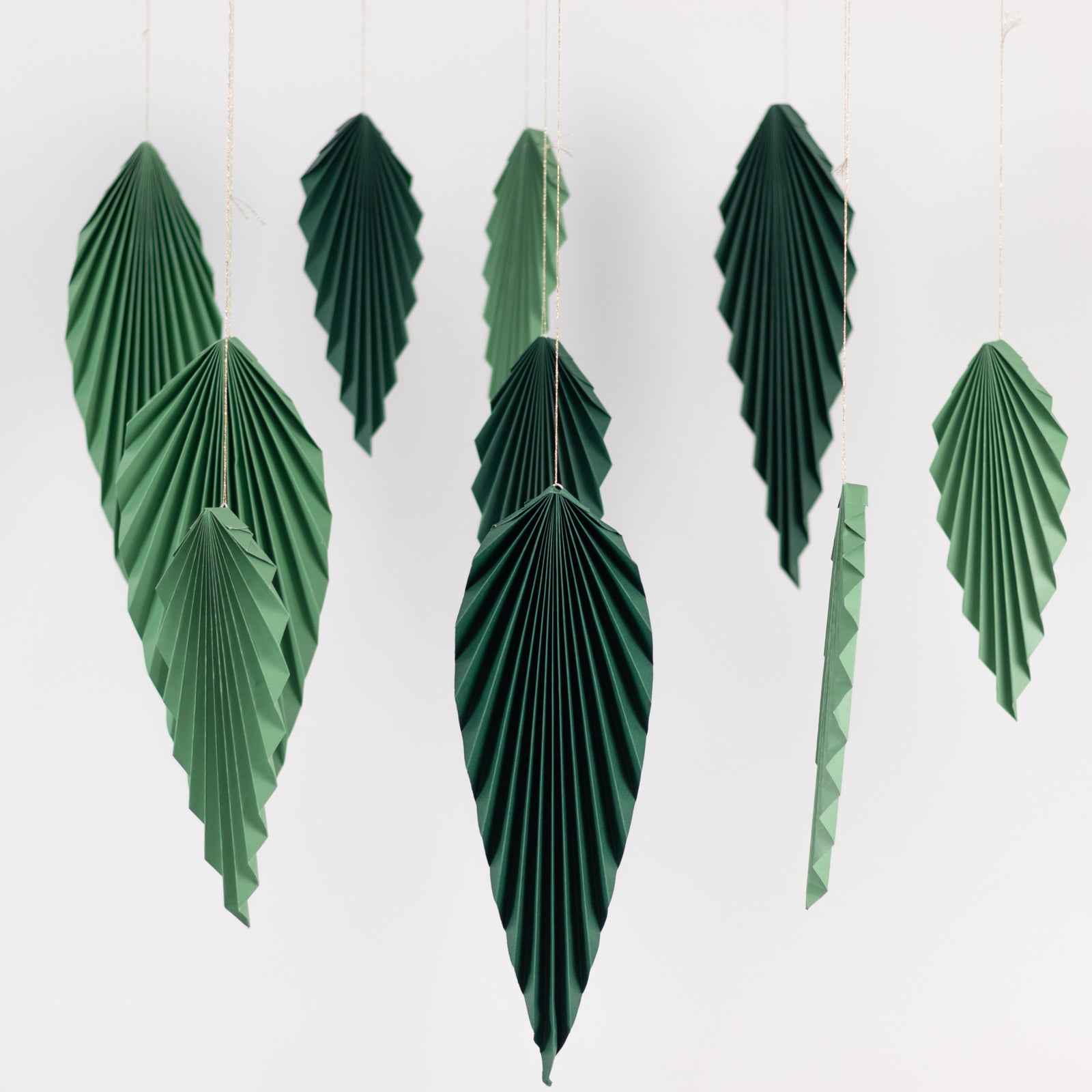 Set of 6 mixed green paper fans for tropical jungle theme decor.