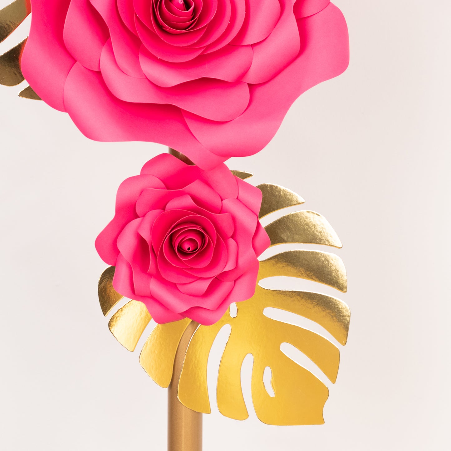 Fuchsia 3D rose paper flowers with gold tropical palm leaves decor.