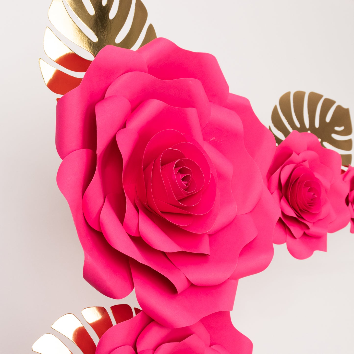 Fuchsia 3D rose paper flowers with gold tropical palm leaves backdrop decor.