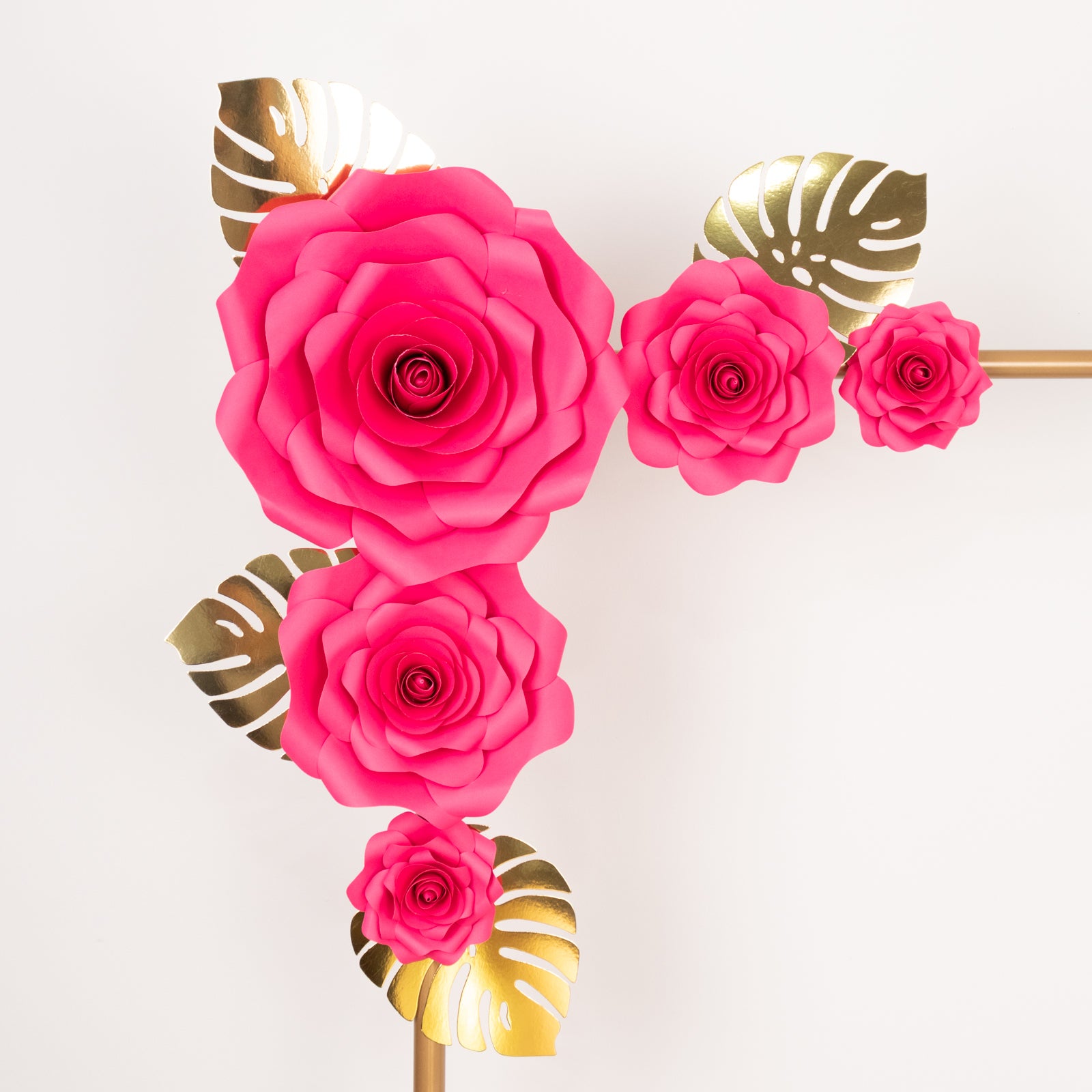 Fuchsia 3D rose paper flowers with gold tropical palm leaves for wall decor.