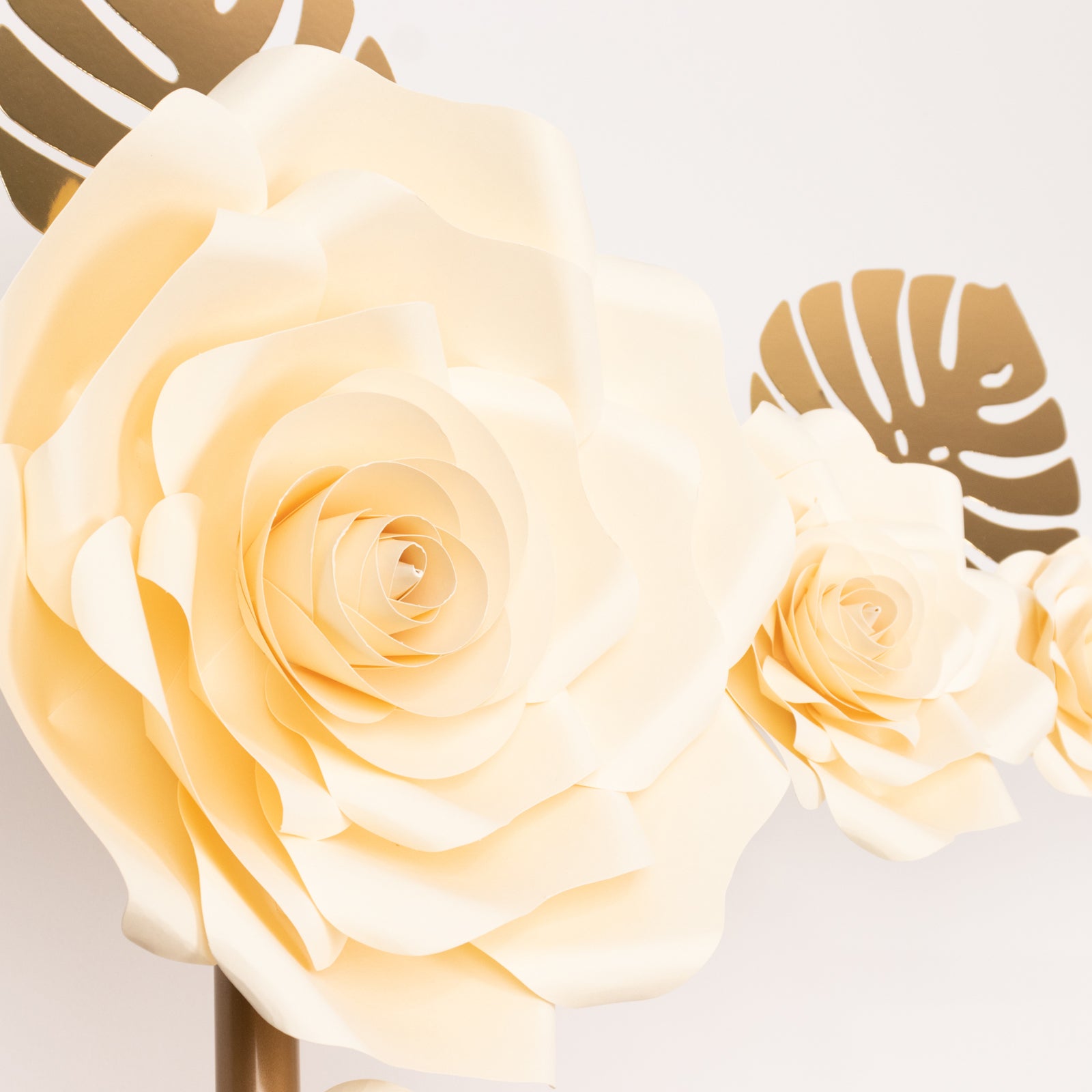 Ivory 3D rose paper flowers with gold tropical palm leaves decor.