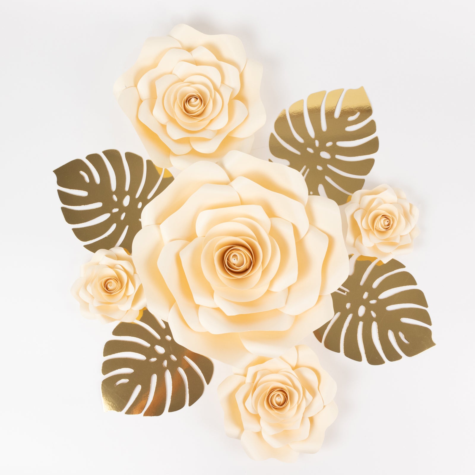 Ivory 3D rose paper flowers with gold palm leaves for party decor.
