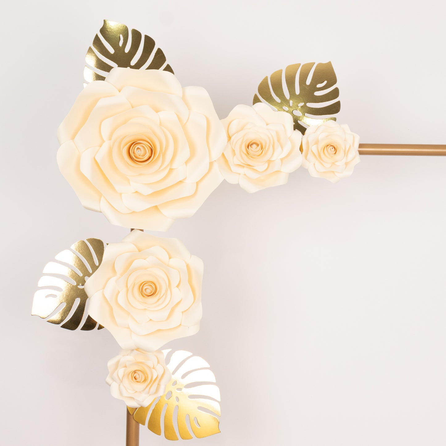 Ivory 3D rose paper flowers with gold palm leaves for party decor.