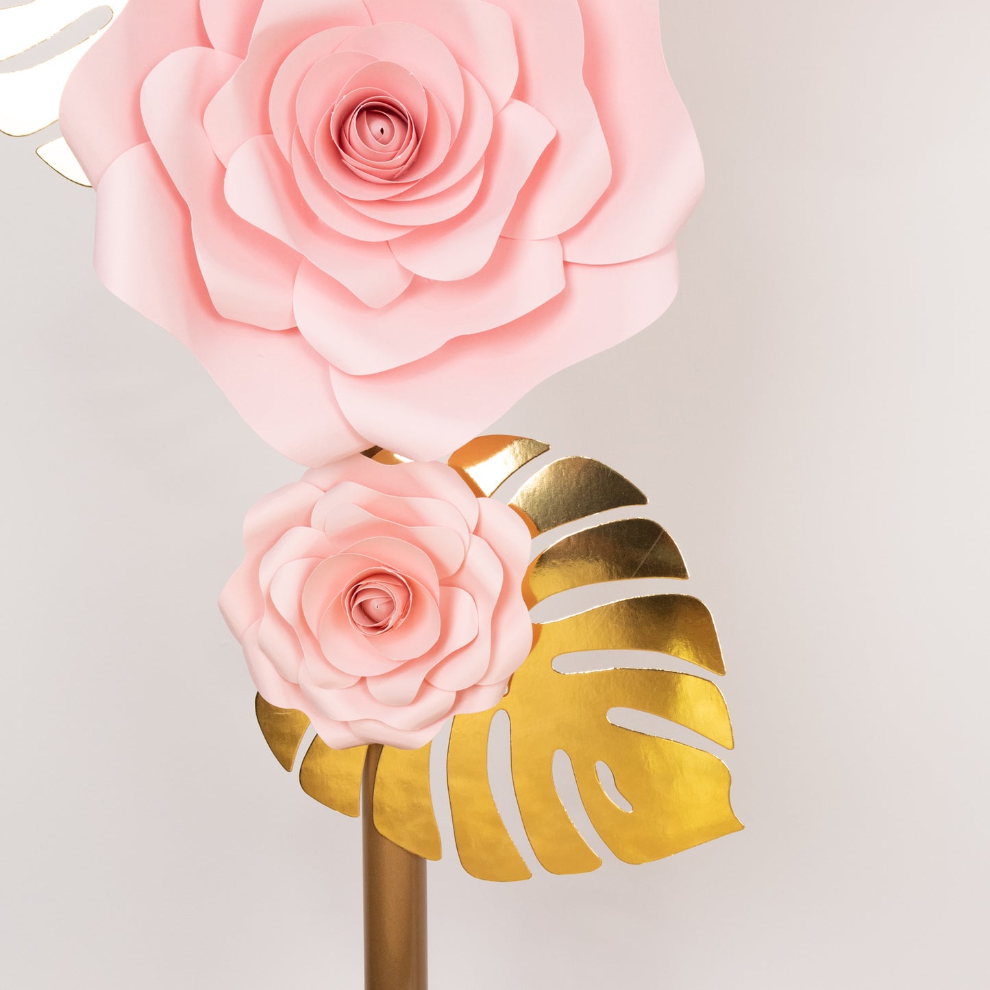Set of pink 3D rose paper flowers with gold palm leaves for wall decor.