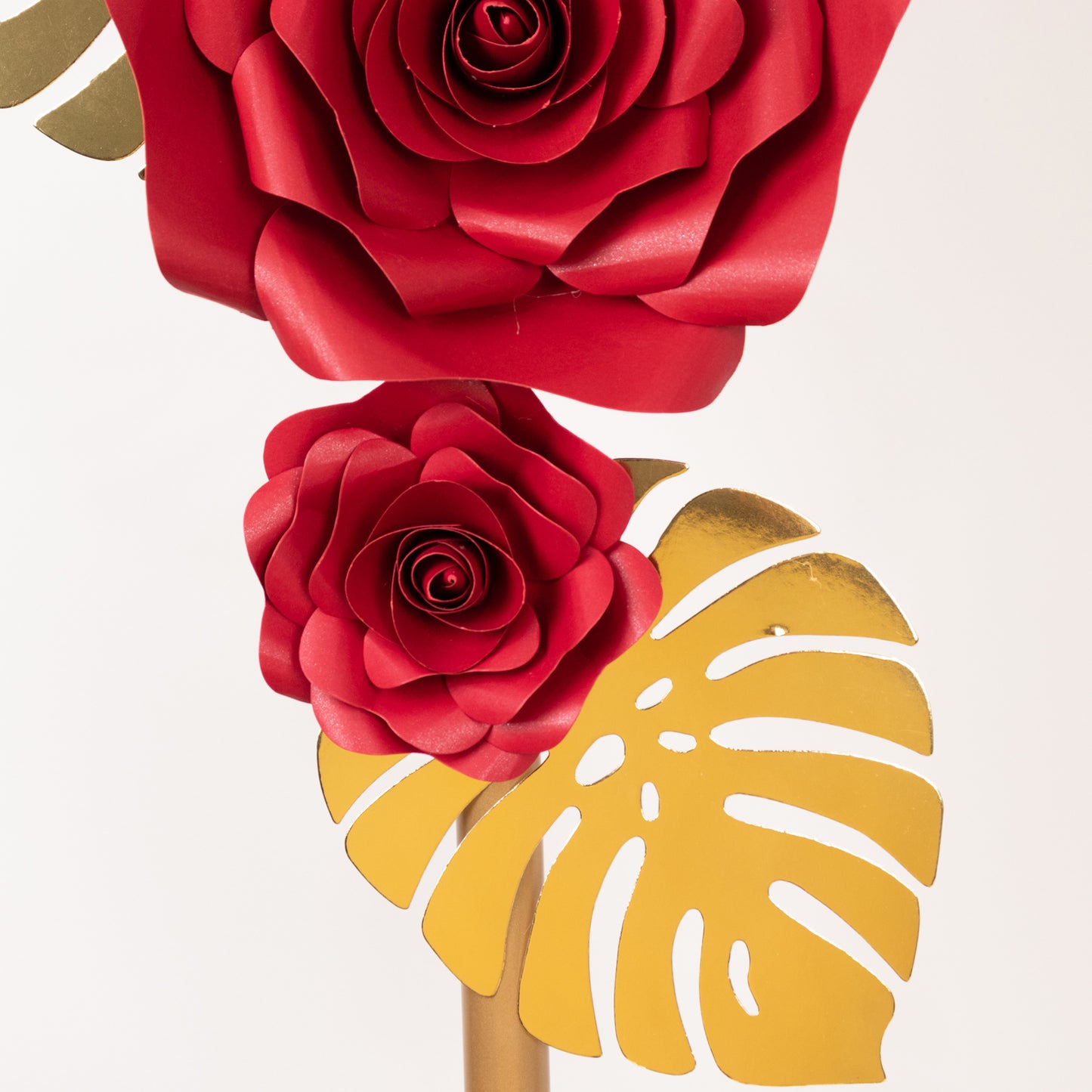 Set of red 3D rose paper flowers with gold palm leaves for wall decor.