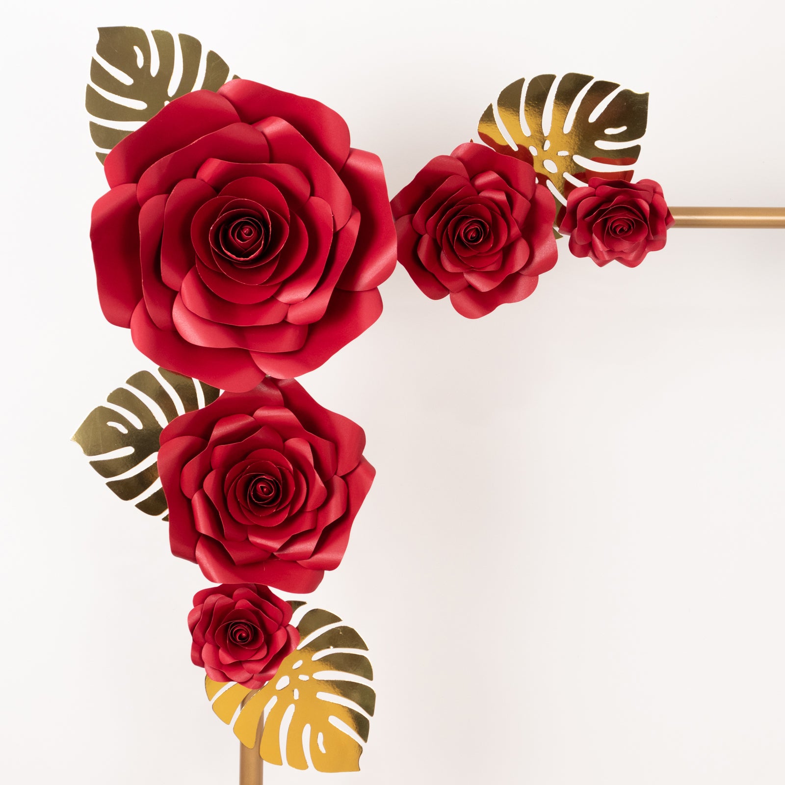 Red 3D rose paper flowers with gold tropical palm leaves decor.