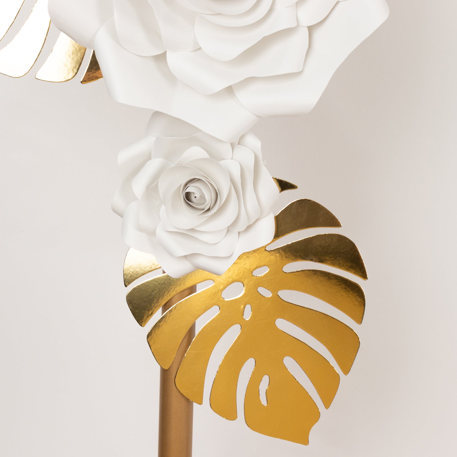White 3D rose paper flowers with gold palm leaves decoration.