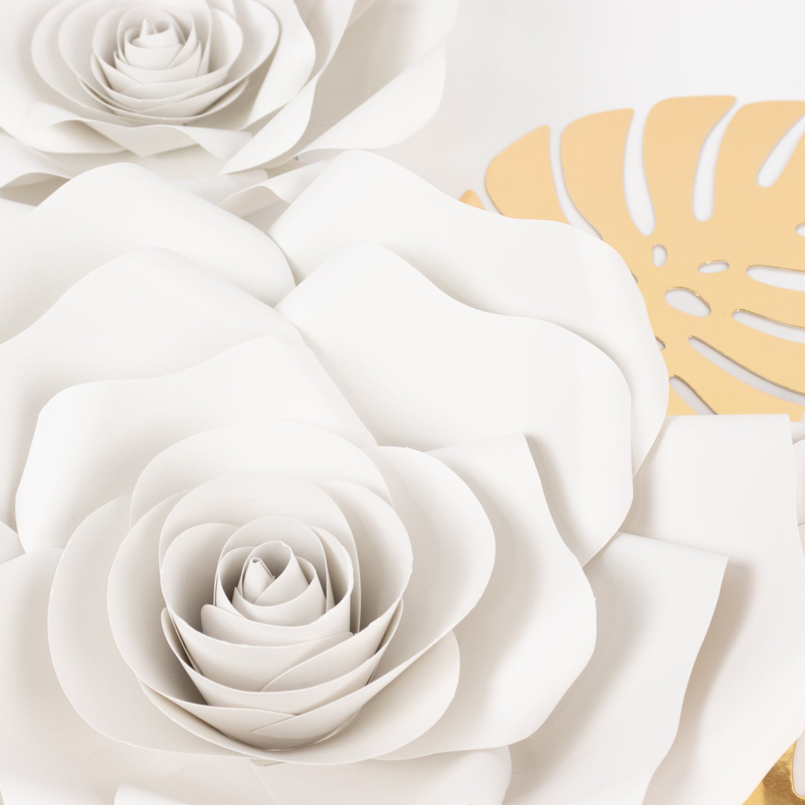 Set of 9 white 3D rose paper flowers with gold palm leaves.