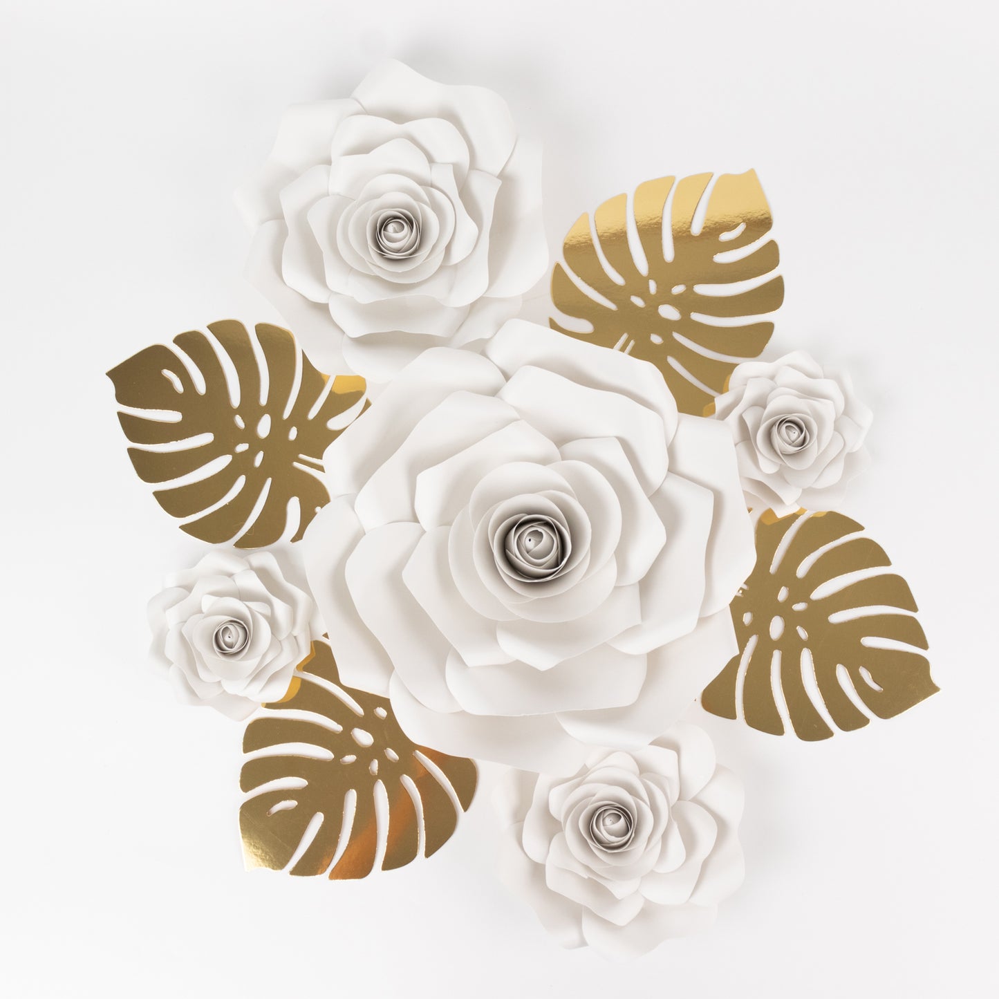 White 3D rose paper flowers with gold tropical palm leaves decor.