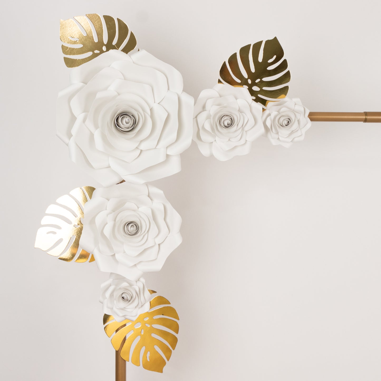White 3D rose paper flowers with gold tropical palm leaves decor.