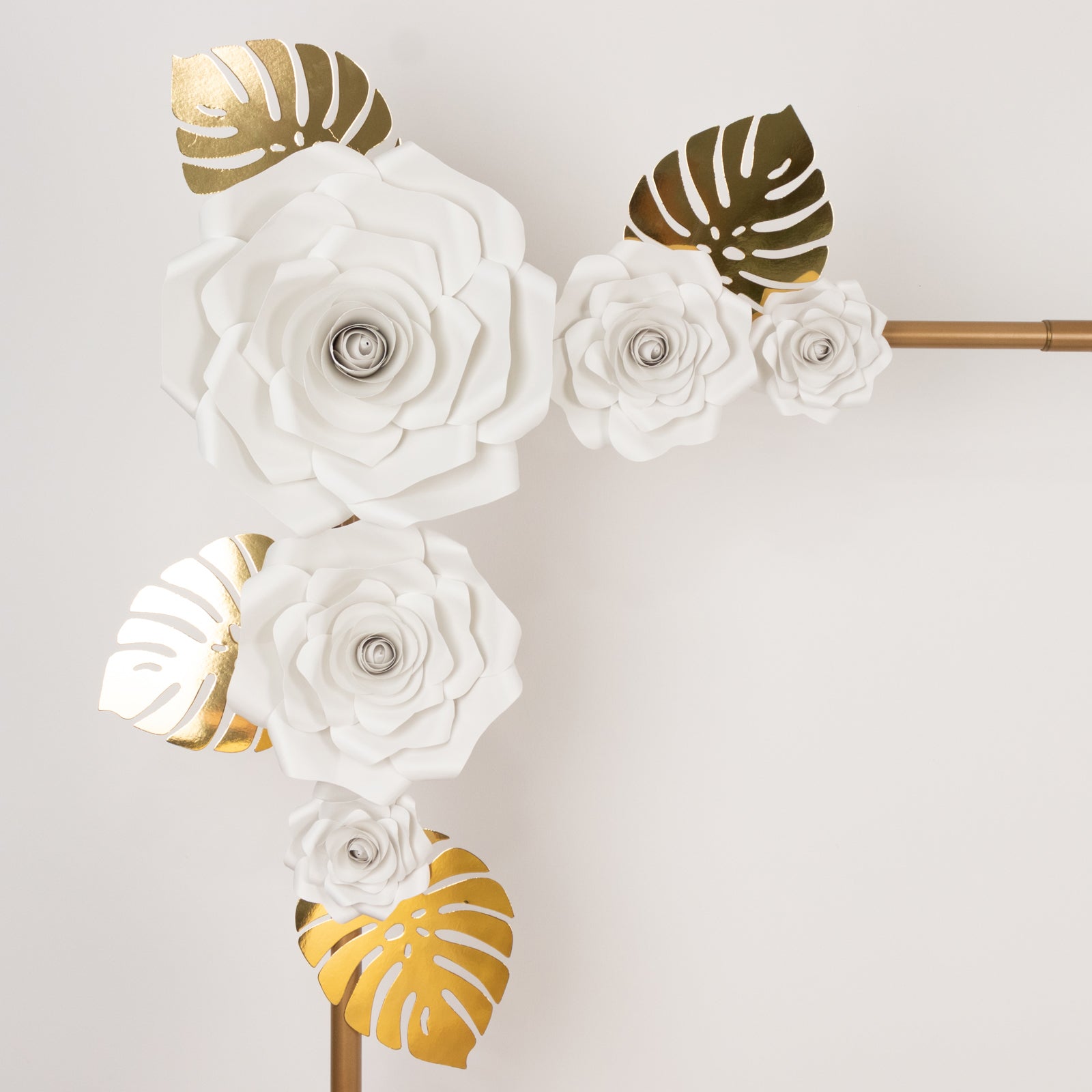 White 3D rose paper flowers with gold tropical palm leaves decor.