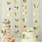 Gold 3D paper butterfly garland streamers hanging at a festive party.