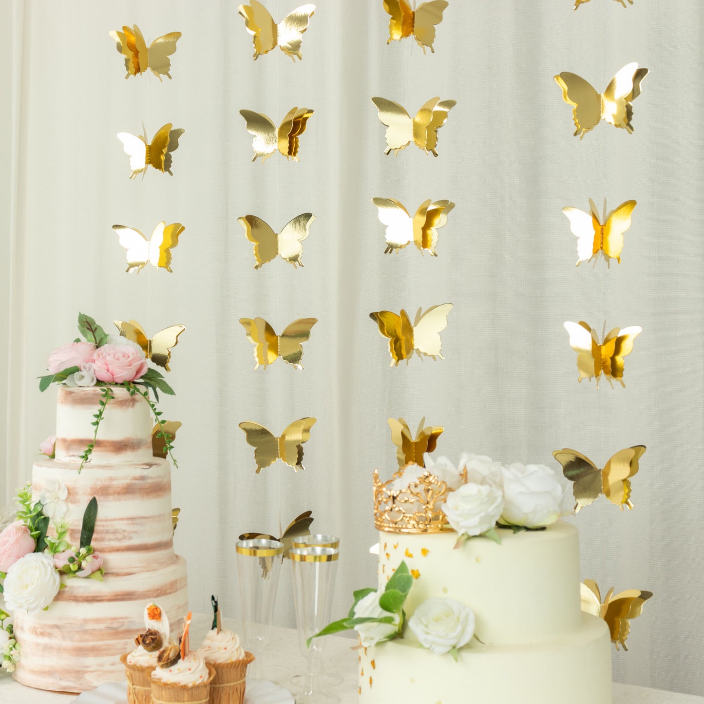 Gold 3D paper butterfly garland streamers hanging at a festive party.