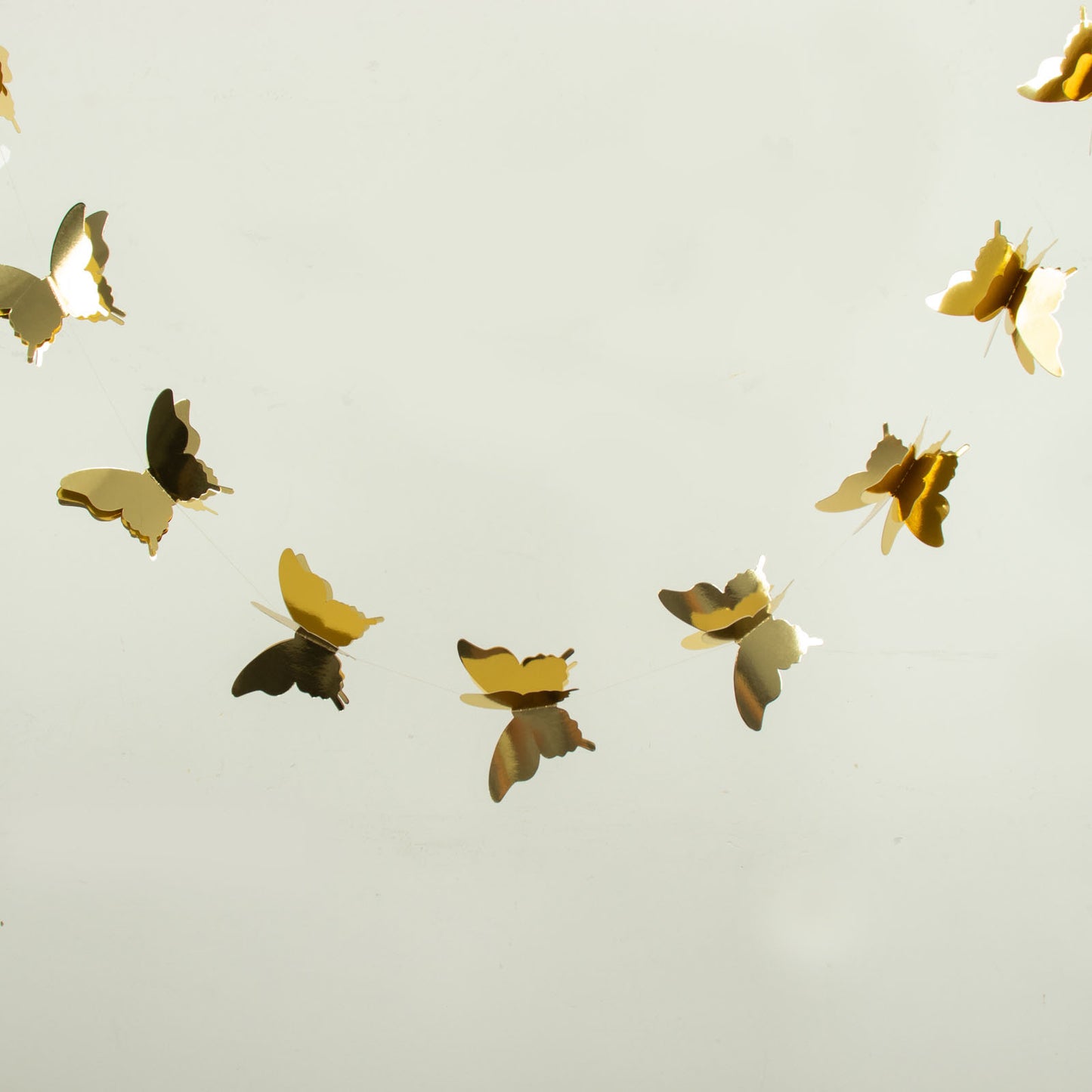 Gold 3D paper butterfly garland streamers for party decoration.