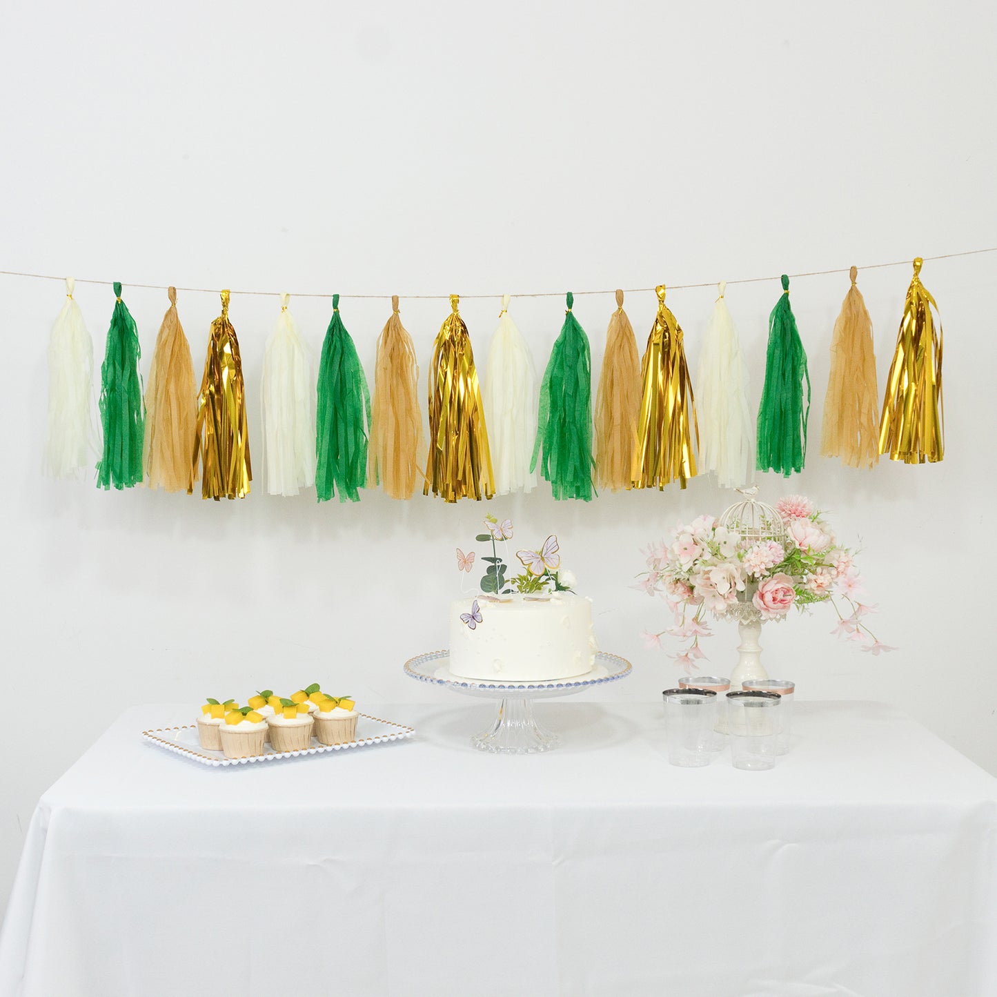 Gold and green foil tassel garland banner decoration on a table.