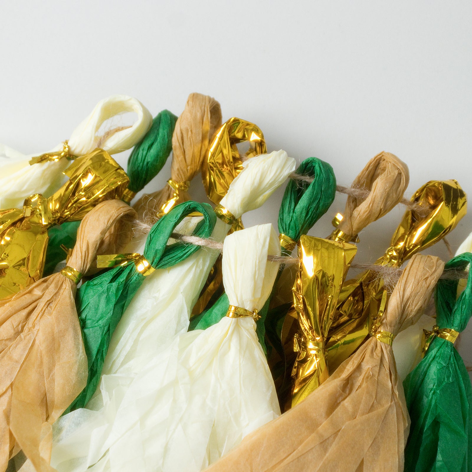 Gold and green foil tassel garland decoration on a hanging string.