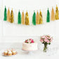 Gold and green foil tassel garland banner decoration above a cake and cupcakes.