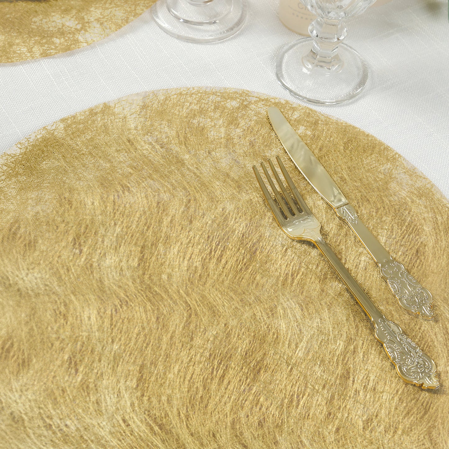 Metallic gold disposable placemat with dining utensils on a table.