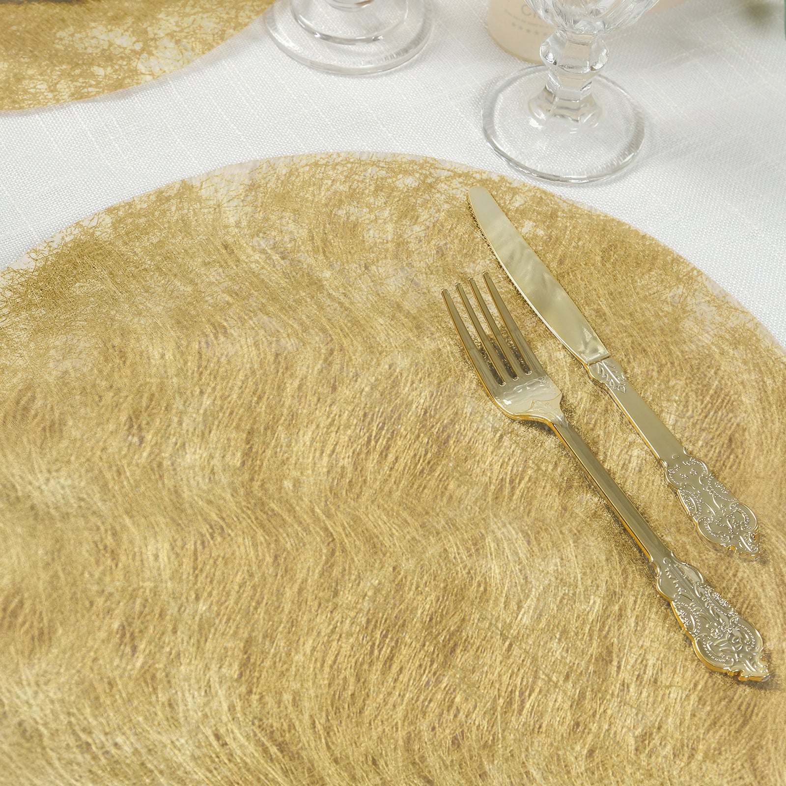 Metallic gold disposable placemat with dining utensils on a table.