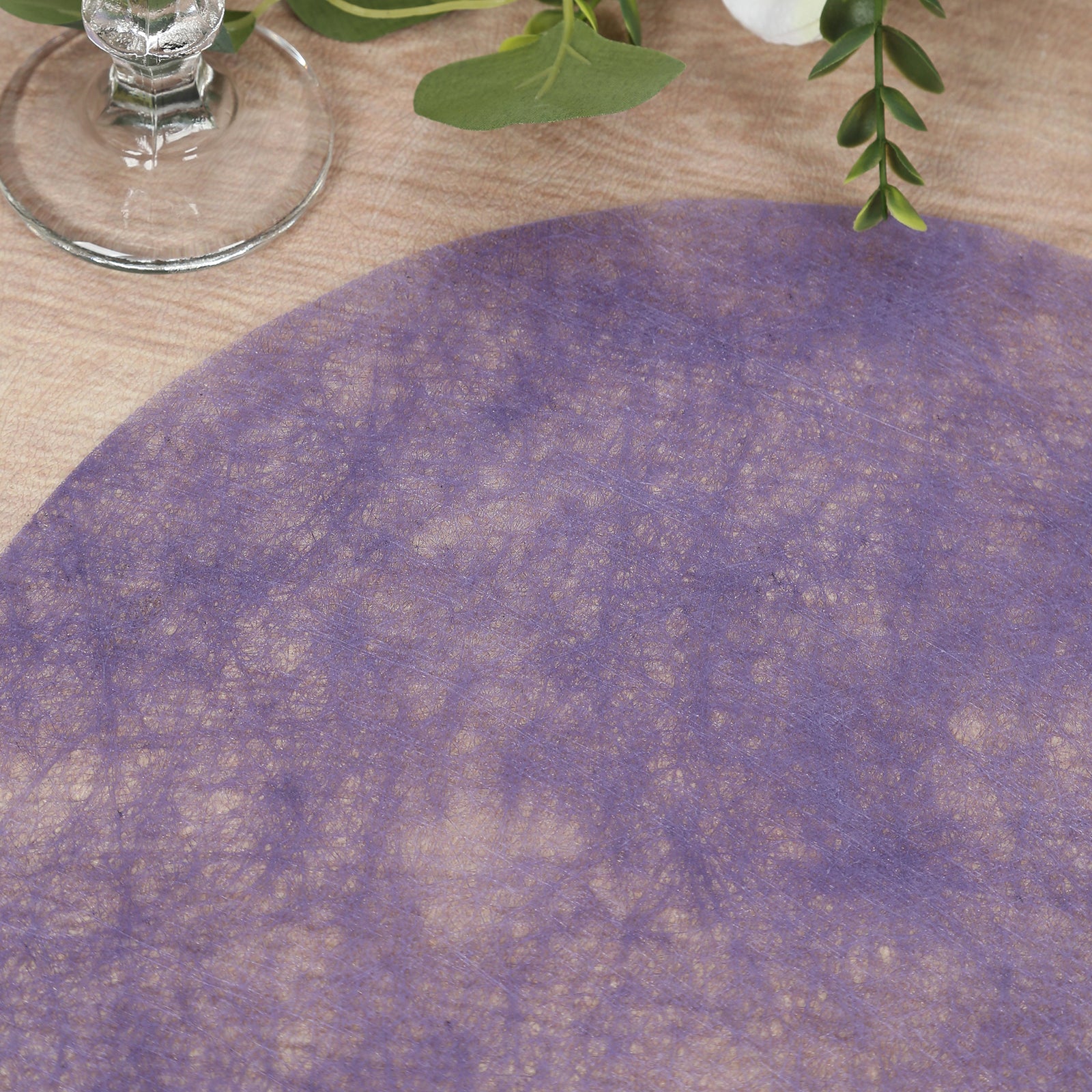 Lavender lilac round placemat on a wooden table surface.