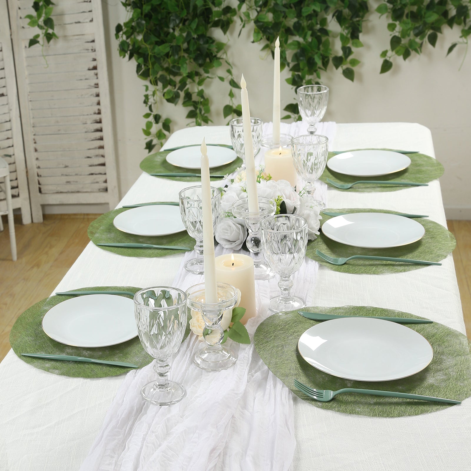 Olive green disposable placemats on a dining table setting.