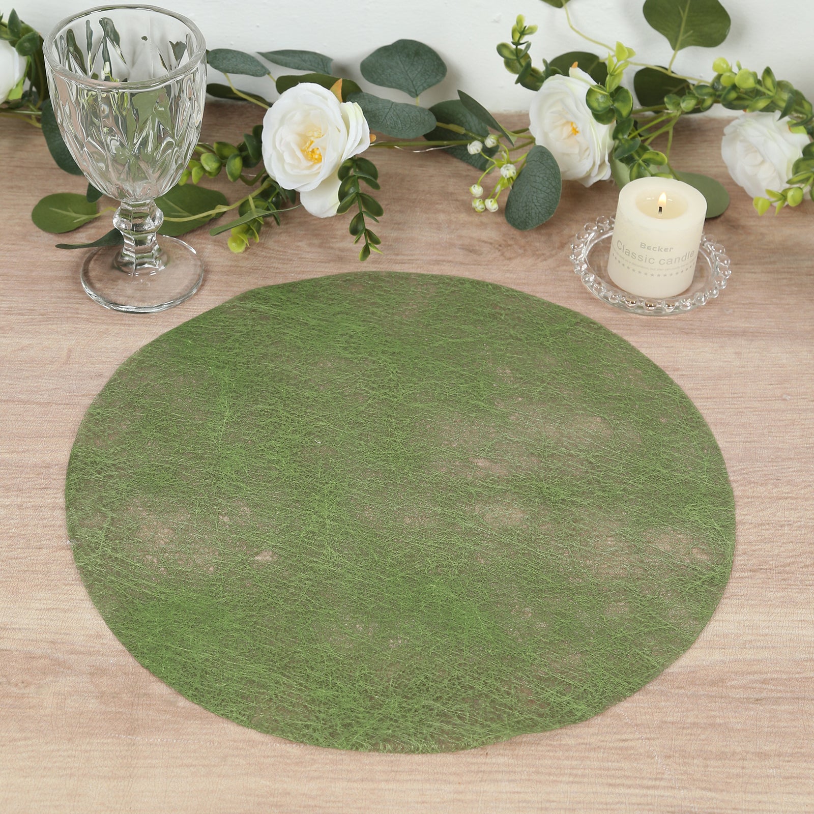 Olive green round disposable placemat on a wooden table setting.