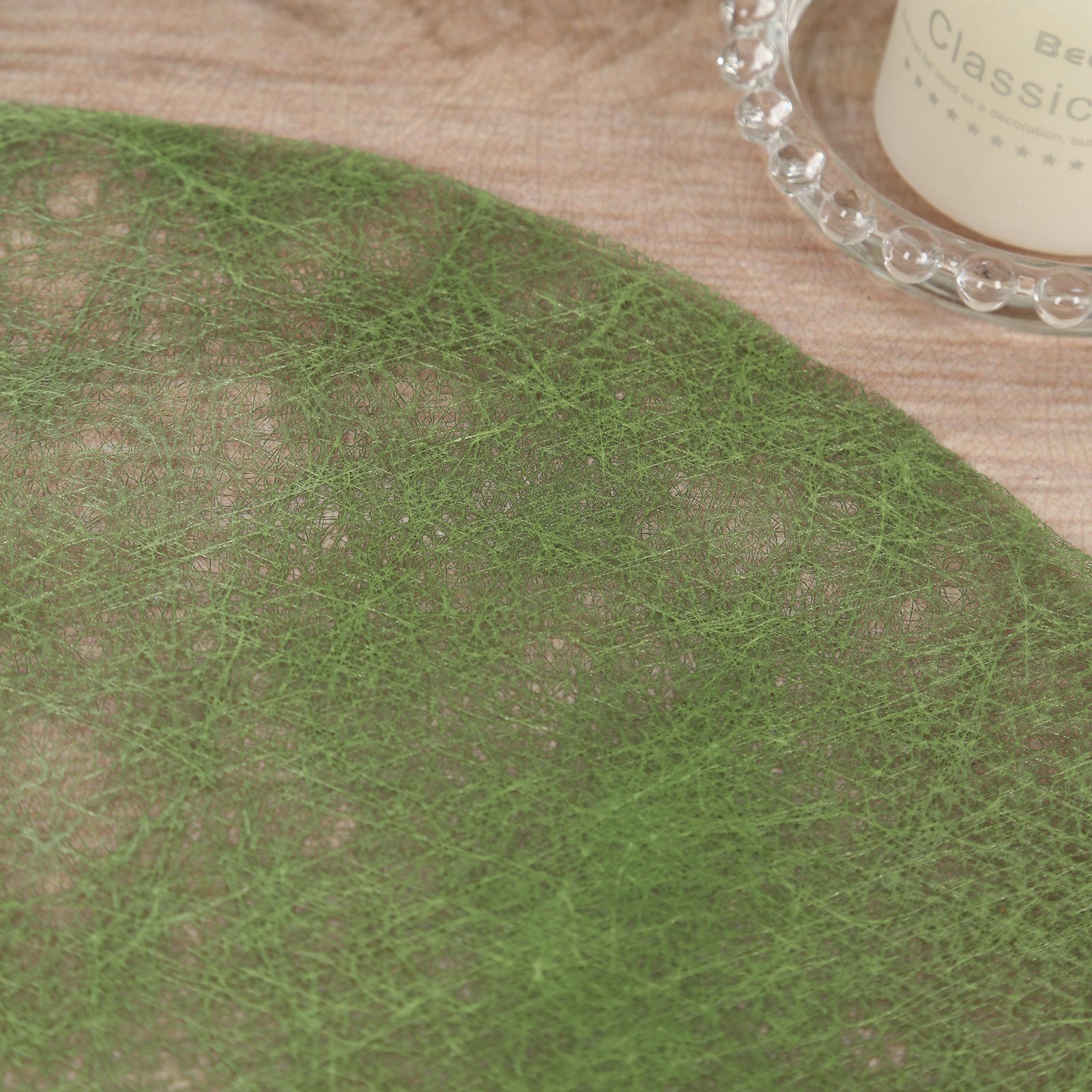 Olive green disposable round placemat on a wooden table.