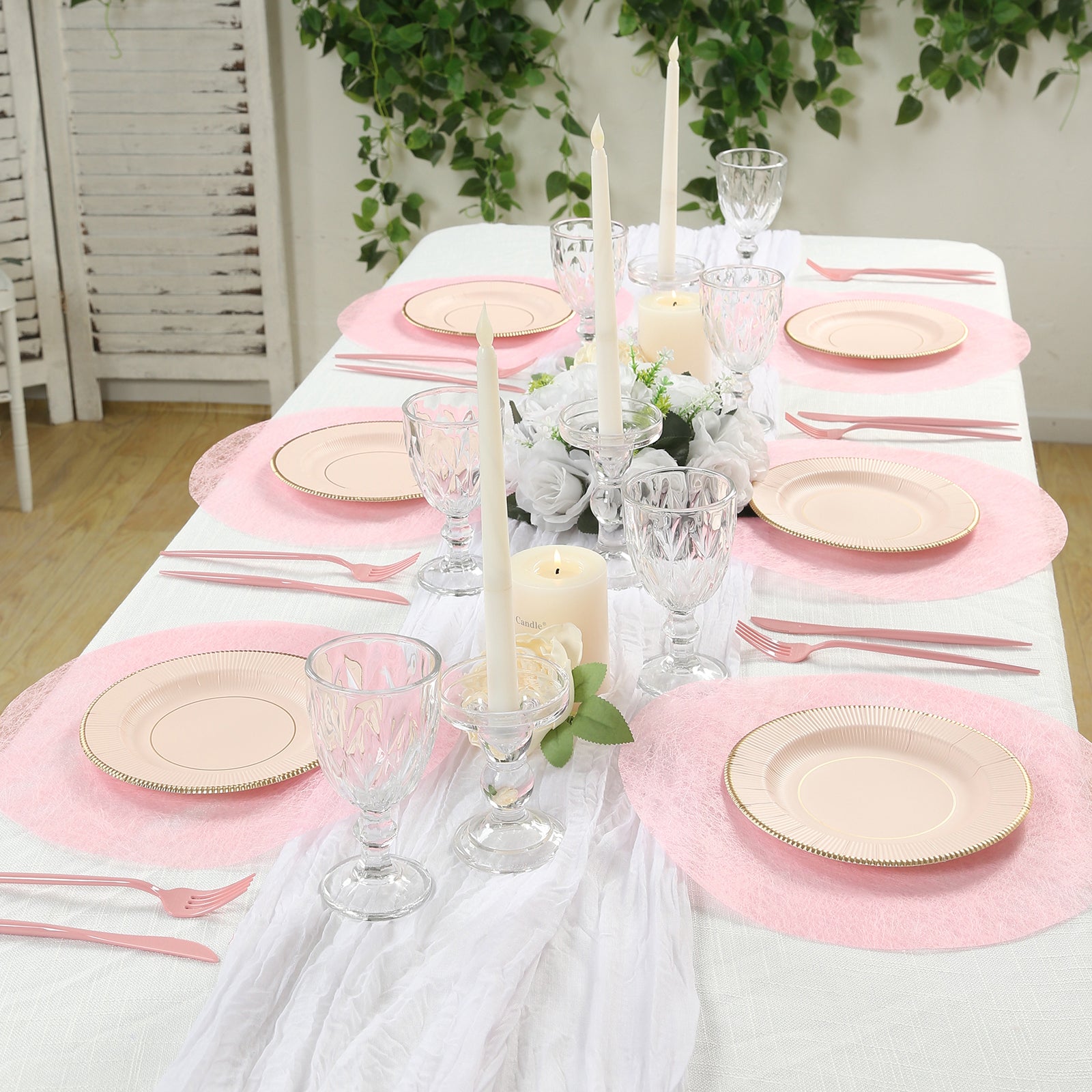 Pink disposable placemats on a dining table with elegant decor.