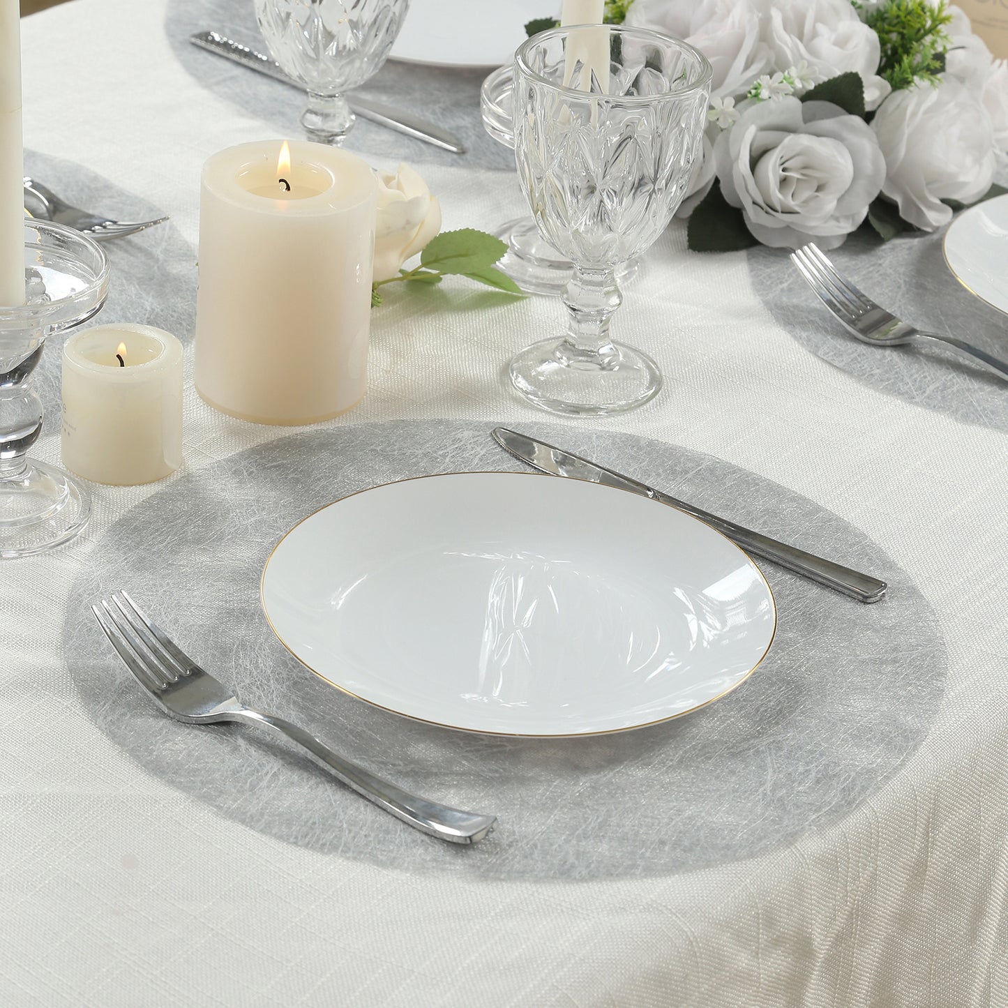 Metallic silver round placemat on a dining table setting.