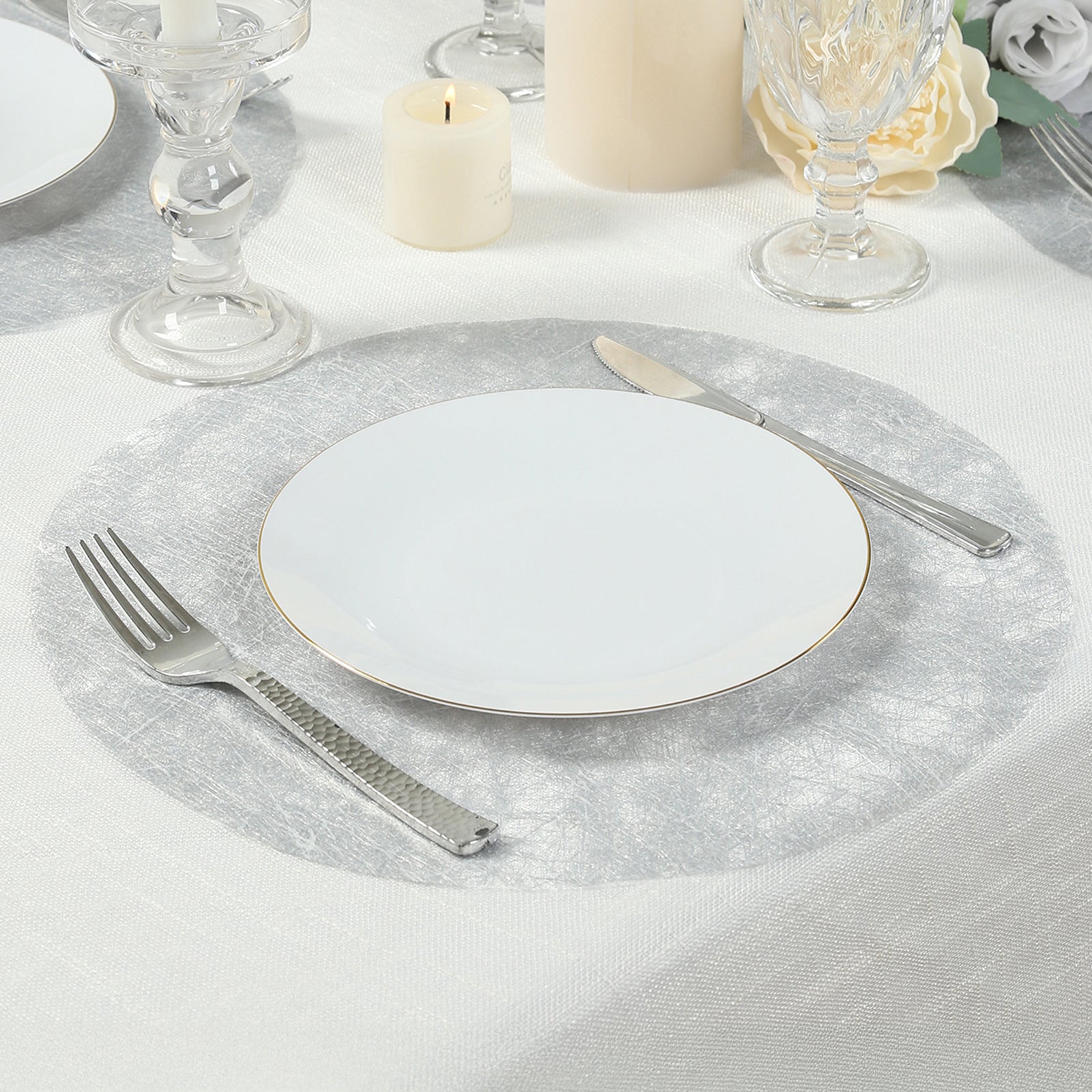 Metallic silver disposable placemat on a dining table setting.