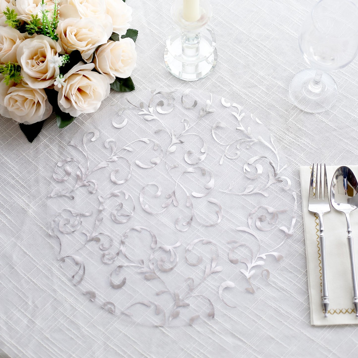 Metallic silver sheer organza round placemat with embossed floral design.