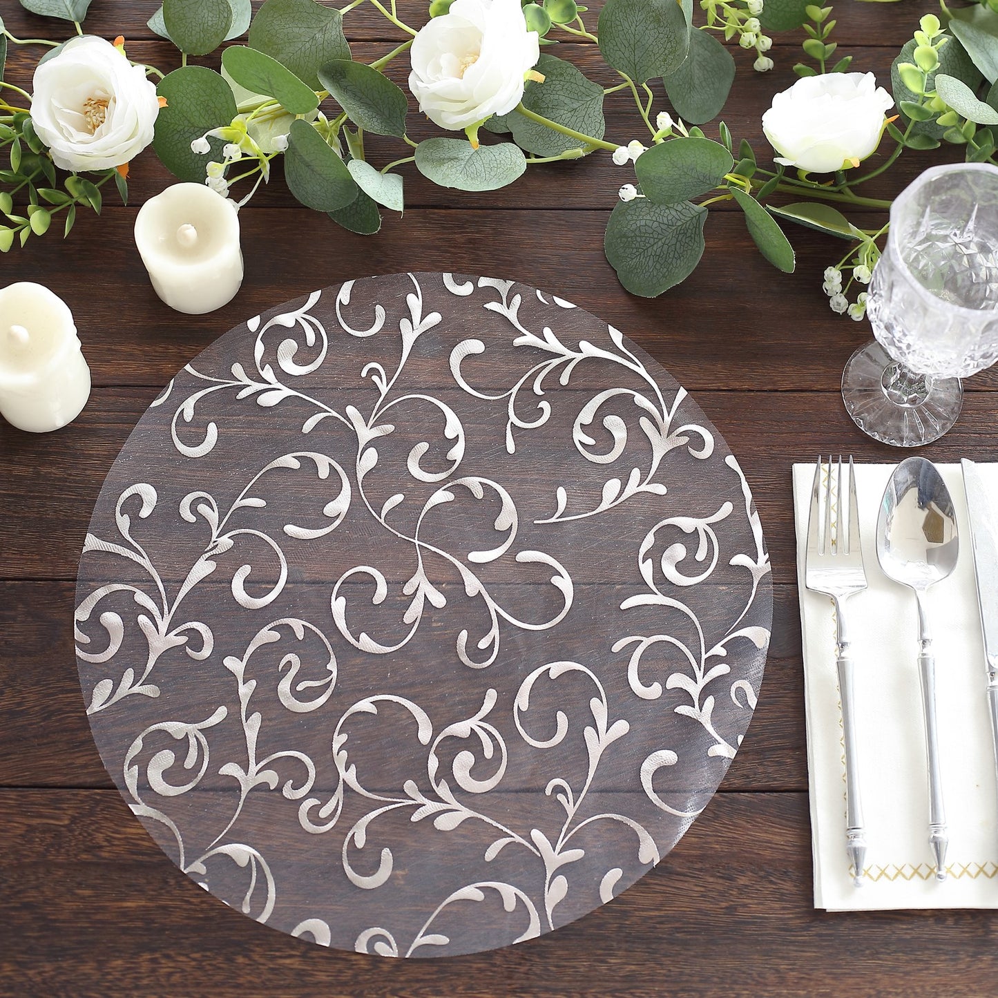 Metallic silver sheer organza round placemat with embossed floral design.