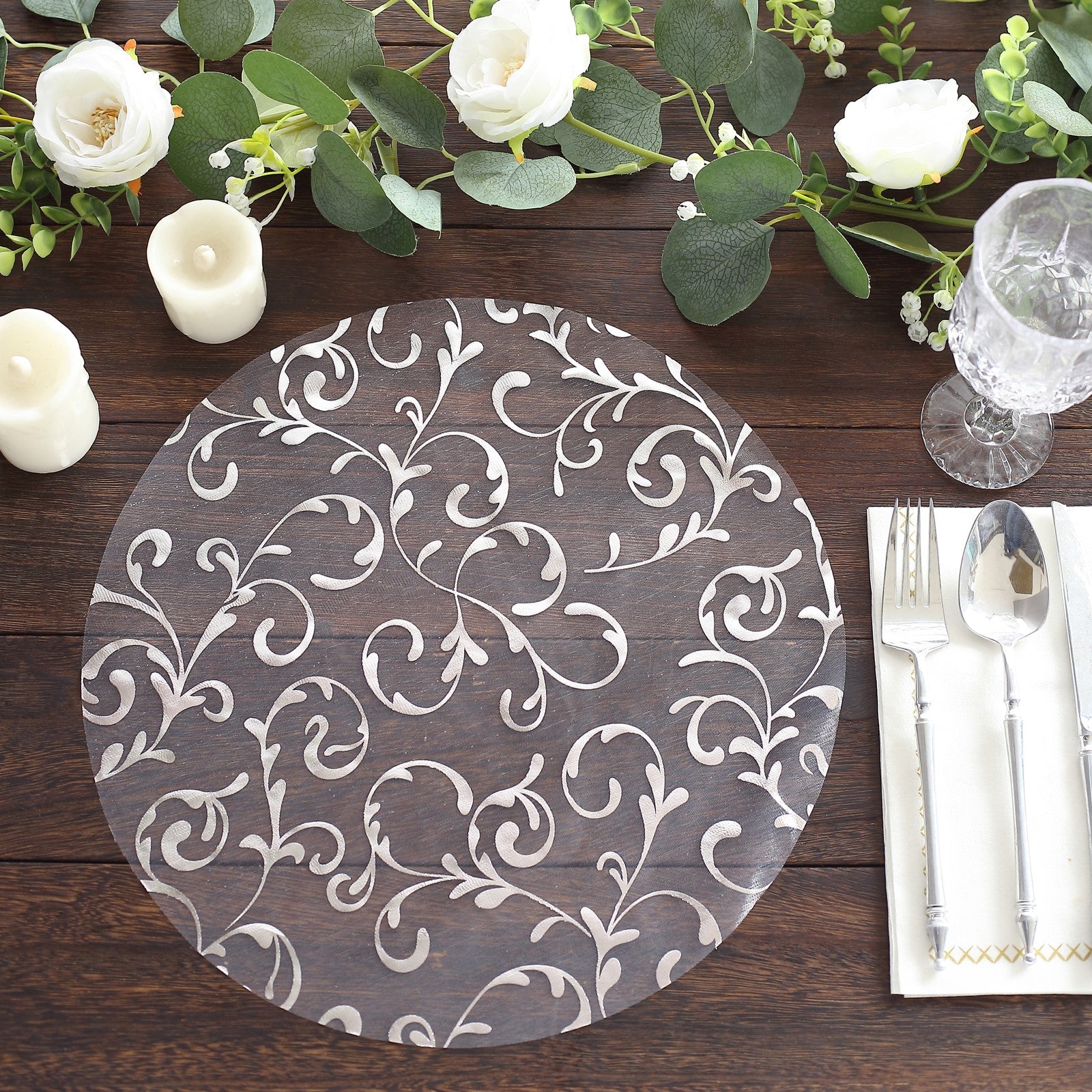 Metallic silver sheer organza round placemat with embossed floral design.