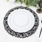 Black round woven fiber placemat with white plates on a marble table.