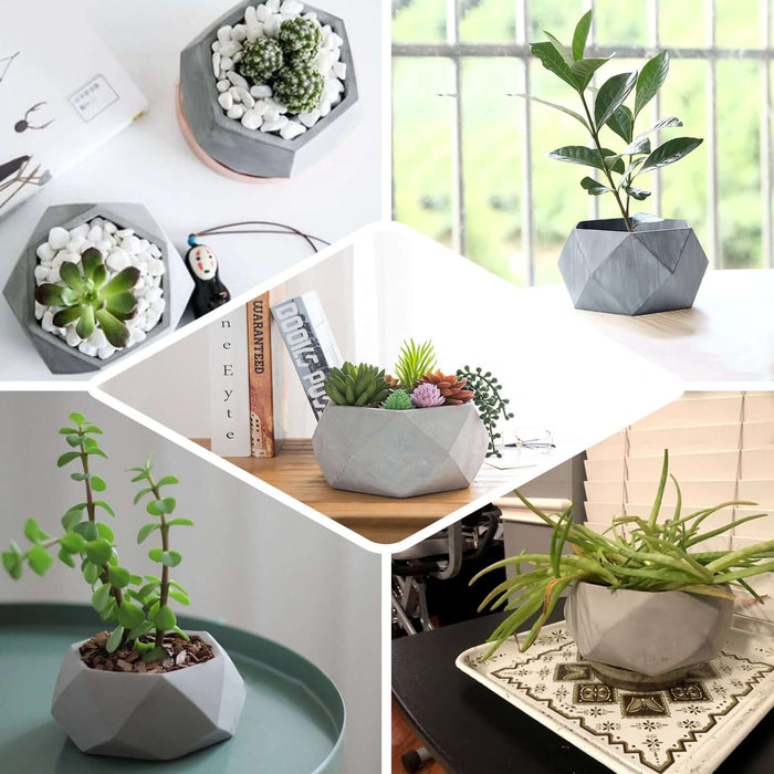 Gray geometric concrete planter with succulents and decorative stones.