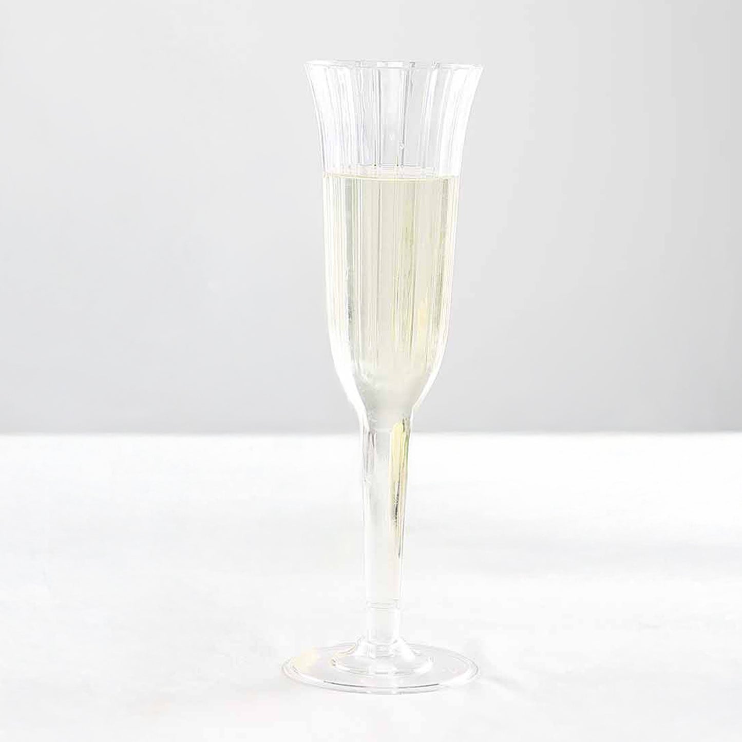 Clear plastic champagne flute with a flared design.