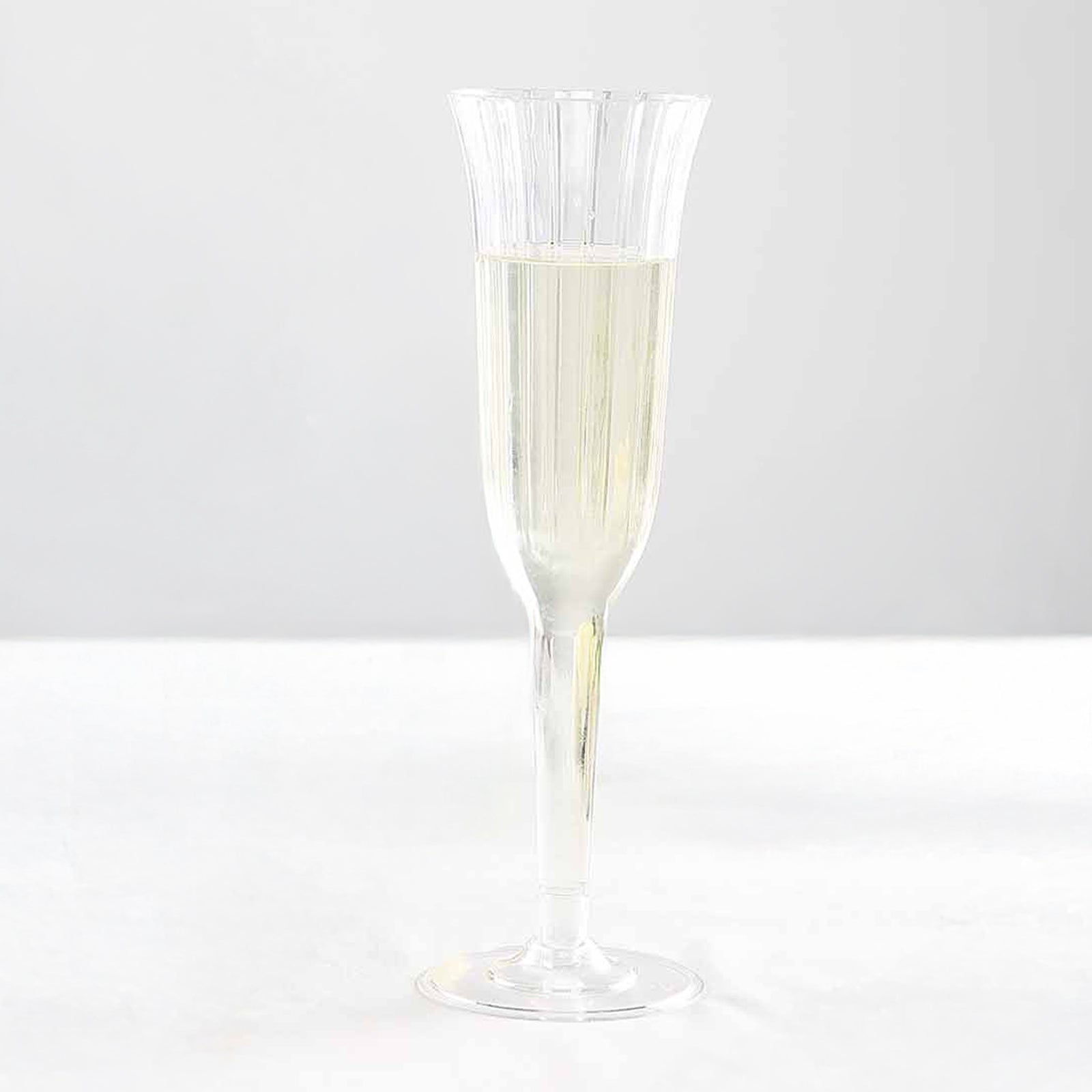 Clear plastic champagne flute with a flared design.