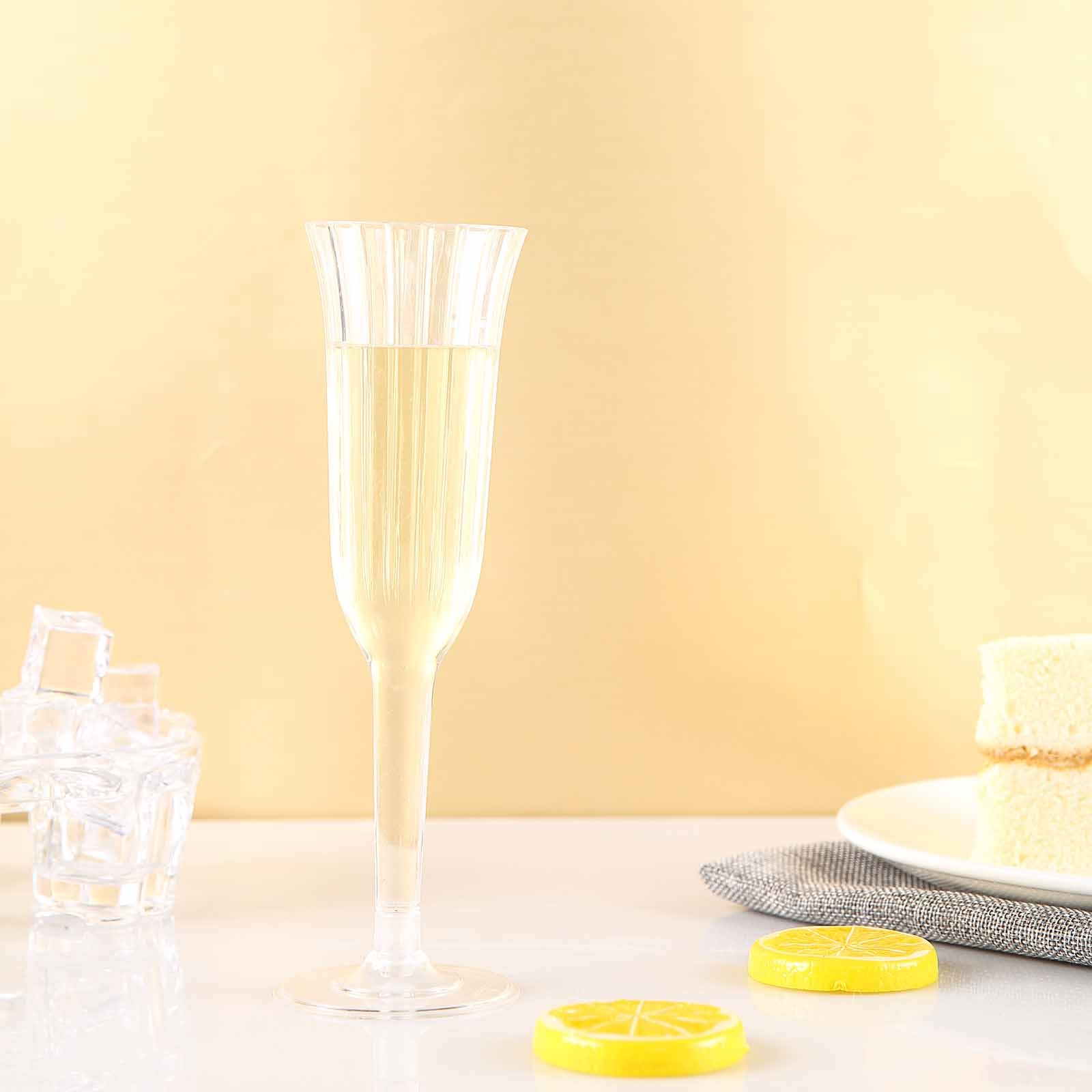 Clear flared plastic champagne flute on a light background.