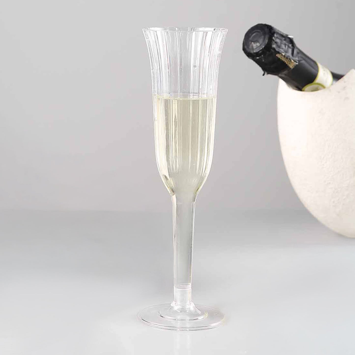 Clear plastic champagne flute with flared design, perfect for toasting.